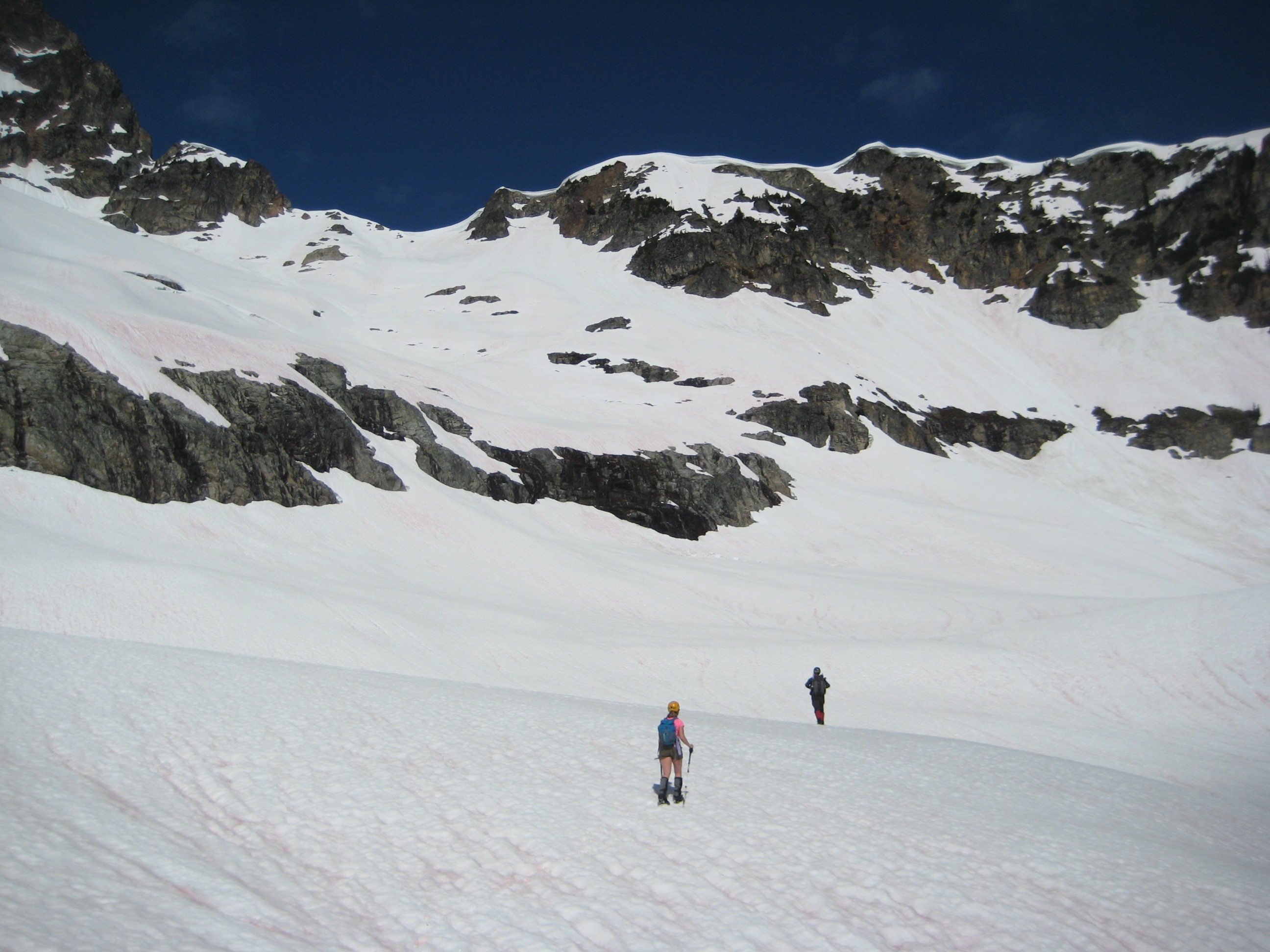 mountain climbers crossing snow filled basin running under the Ragged Ridge in the North Cascades