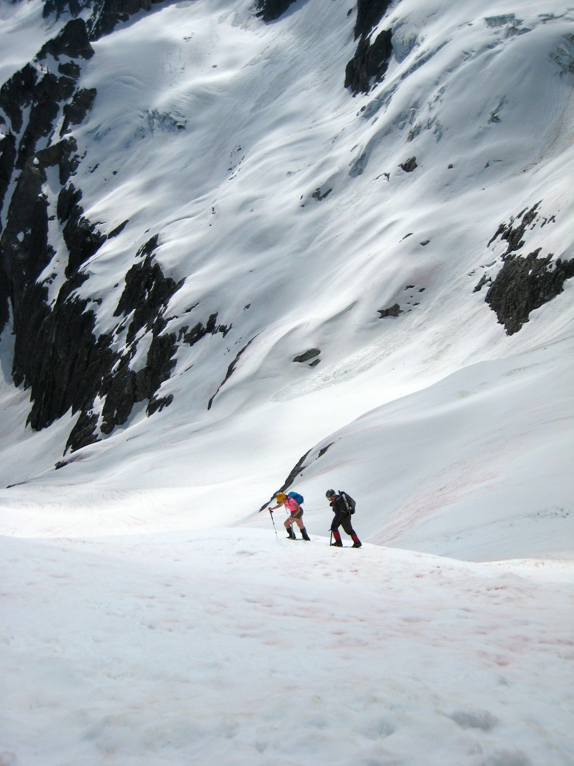 mountain climbers ascending the lower Katsuk Glacier with Ragged Ridge in the North Cascades jetting straight up in the background