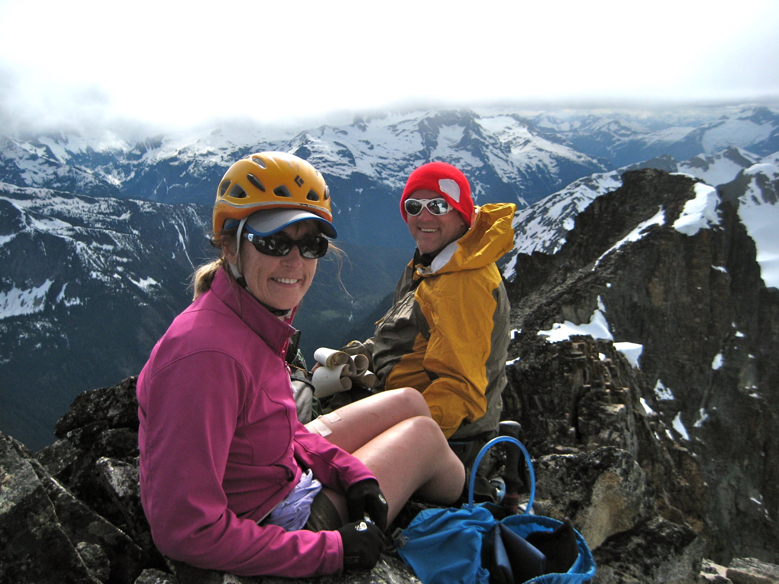 mountain climbers taking a break on the rock horn summit of Kimtah Peak in the North Cascades with high clouds