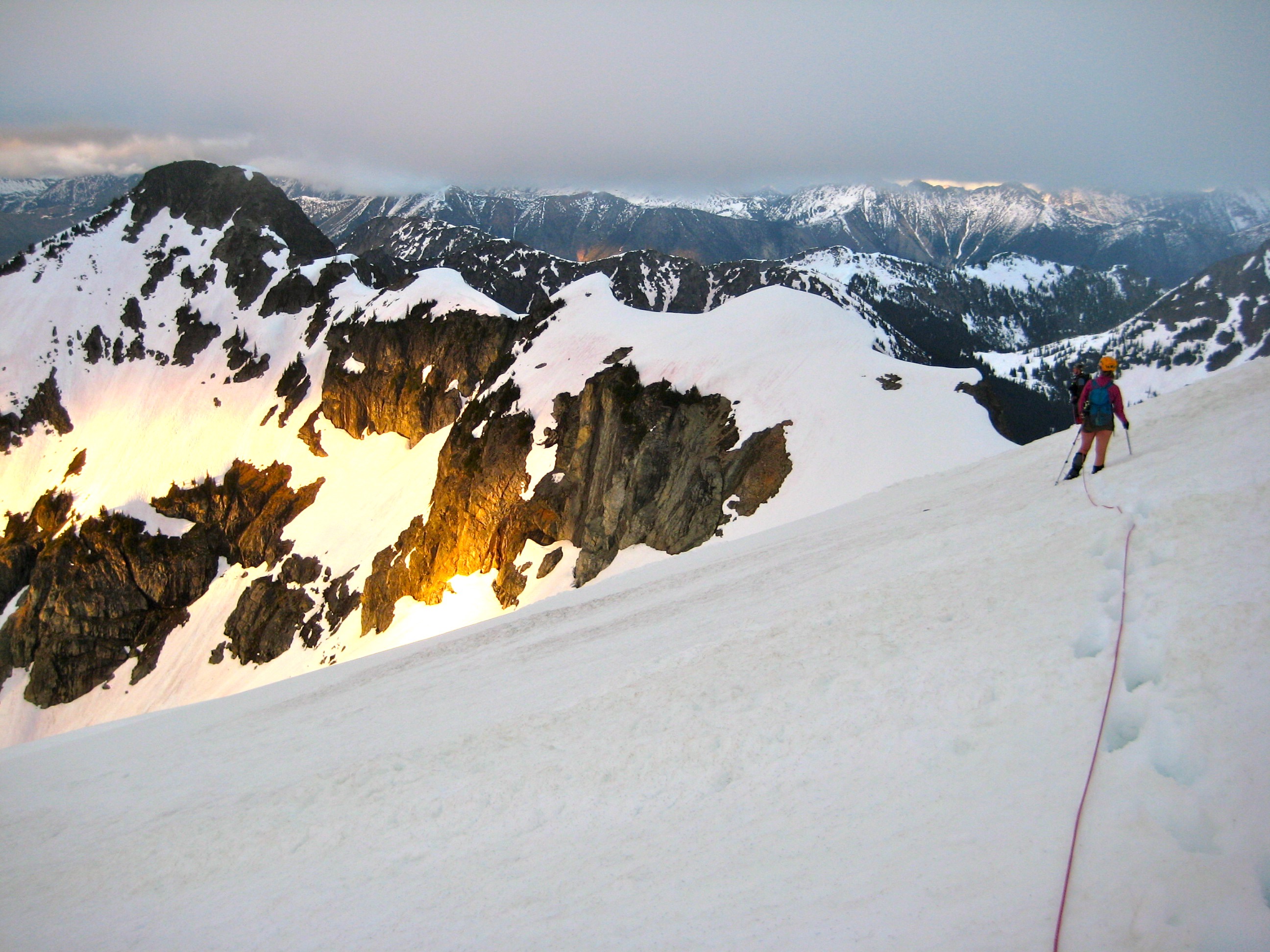 roped mountain climber descending the Kimtah Glacier with evening sun on Ragged Ridge
