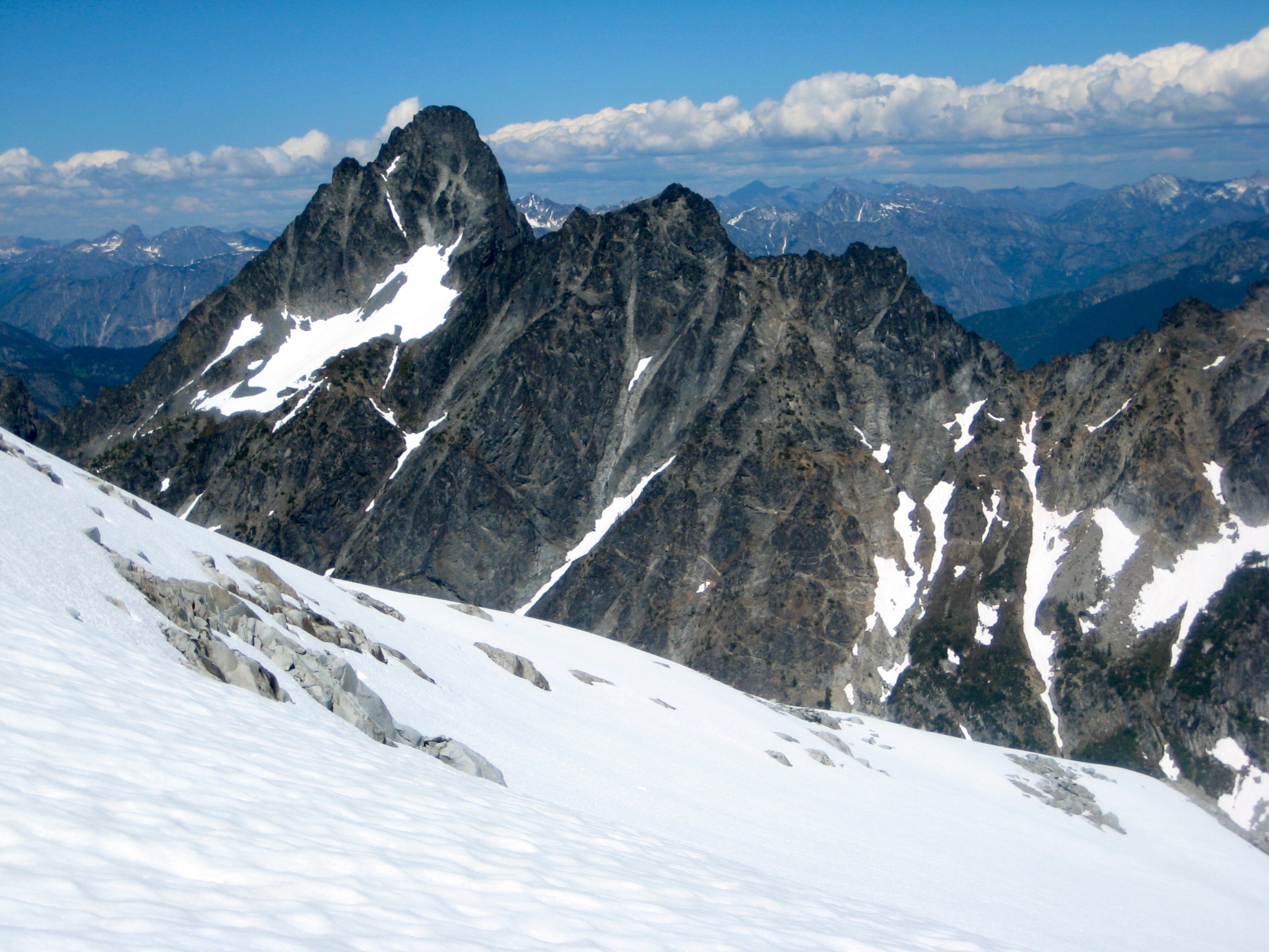 rocky Agnes Mountain with linguring snow patches with snow slopes on the South side of Gunsight Peak in the Glacier Peak WIlderness