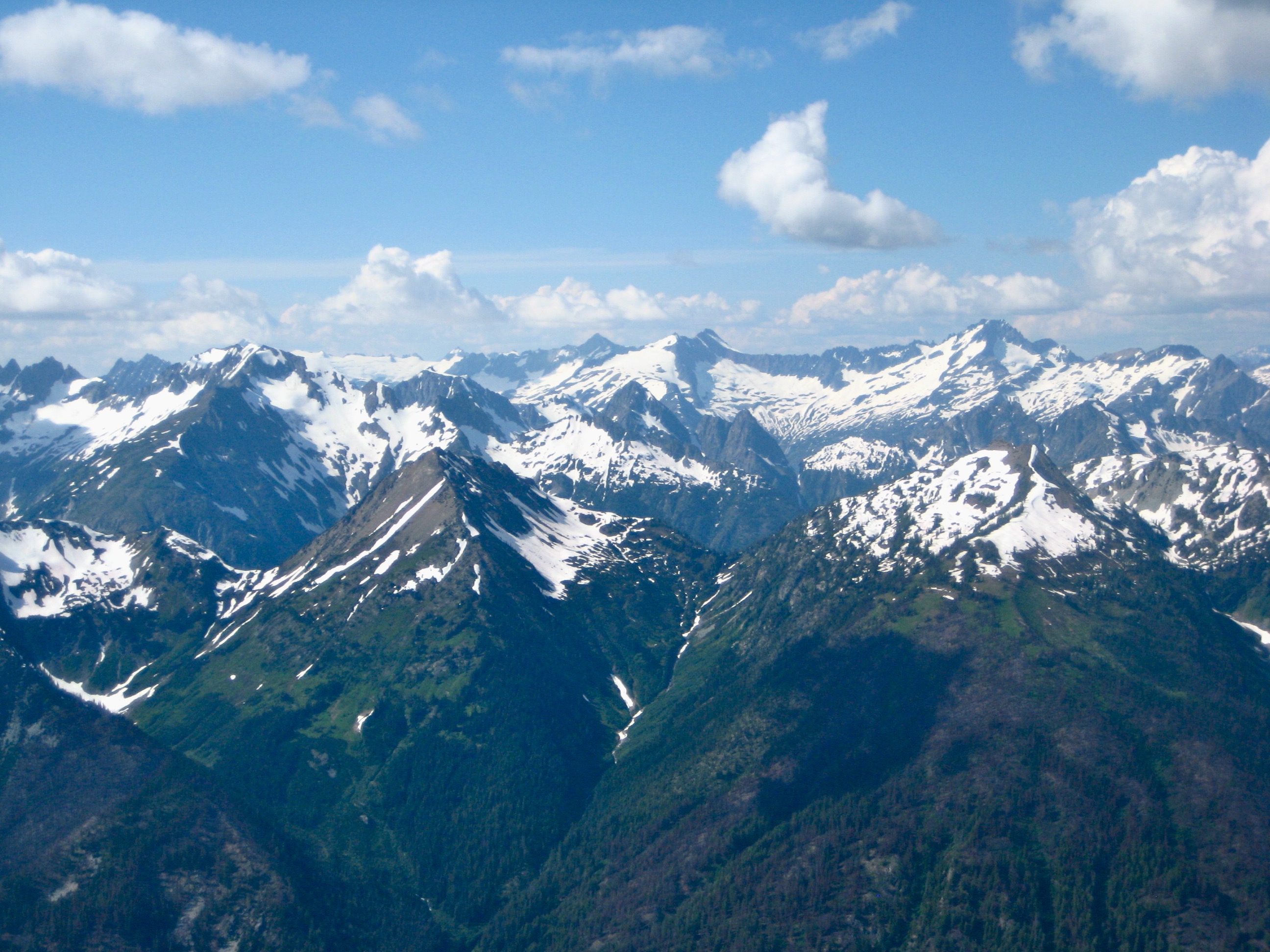 Forbidden Peak and Mount Buckner with linguring snow patches as seen from Agnes Mountain in the Glacier Peak Wilderness