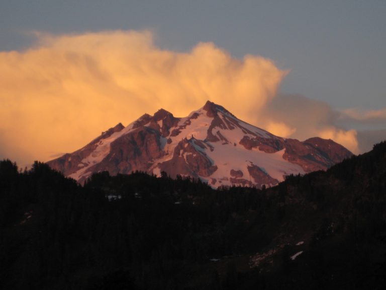 Glacier Peak is capped with pink puffy clouds at sunset in the Cascade Range