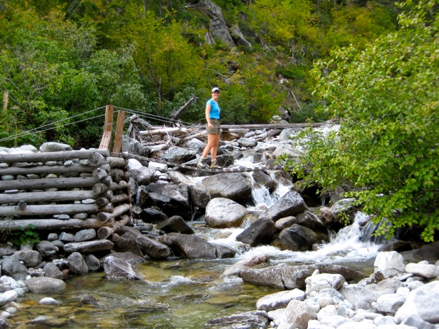 hiker crossing Rainbow Creek suspension bridge in the Stehekin Mountains at the start of the Rainbow Ridge Loop