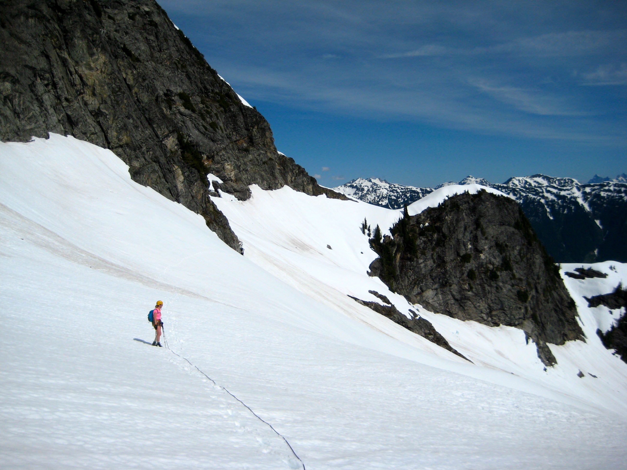 roped mountain climbers traversing the large snow filed basin between Pyramid Ridge and Colonial Glacier in the McAllister Mountains in North Cascades National Park