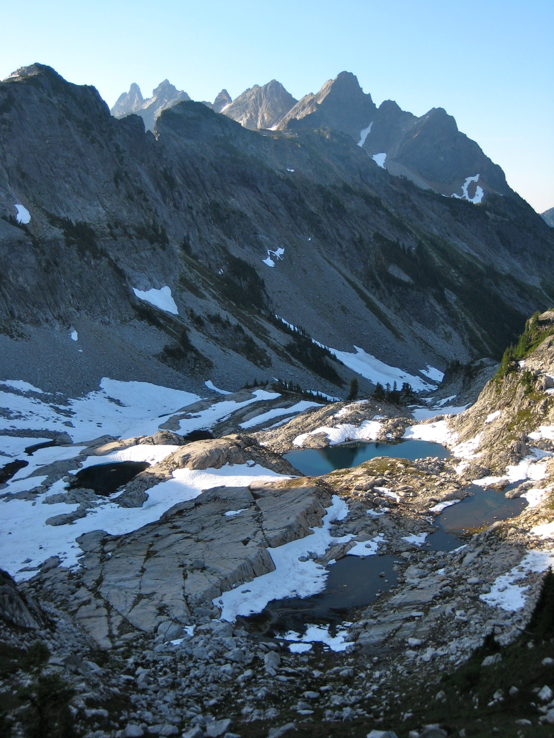 Bears Breast Mountain in the Alpine Lakes WIlderness with Chain Lakes below with snow patches and granite slabs as seen from La Bohn Gap in the Snoqualmie Mountains