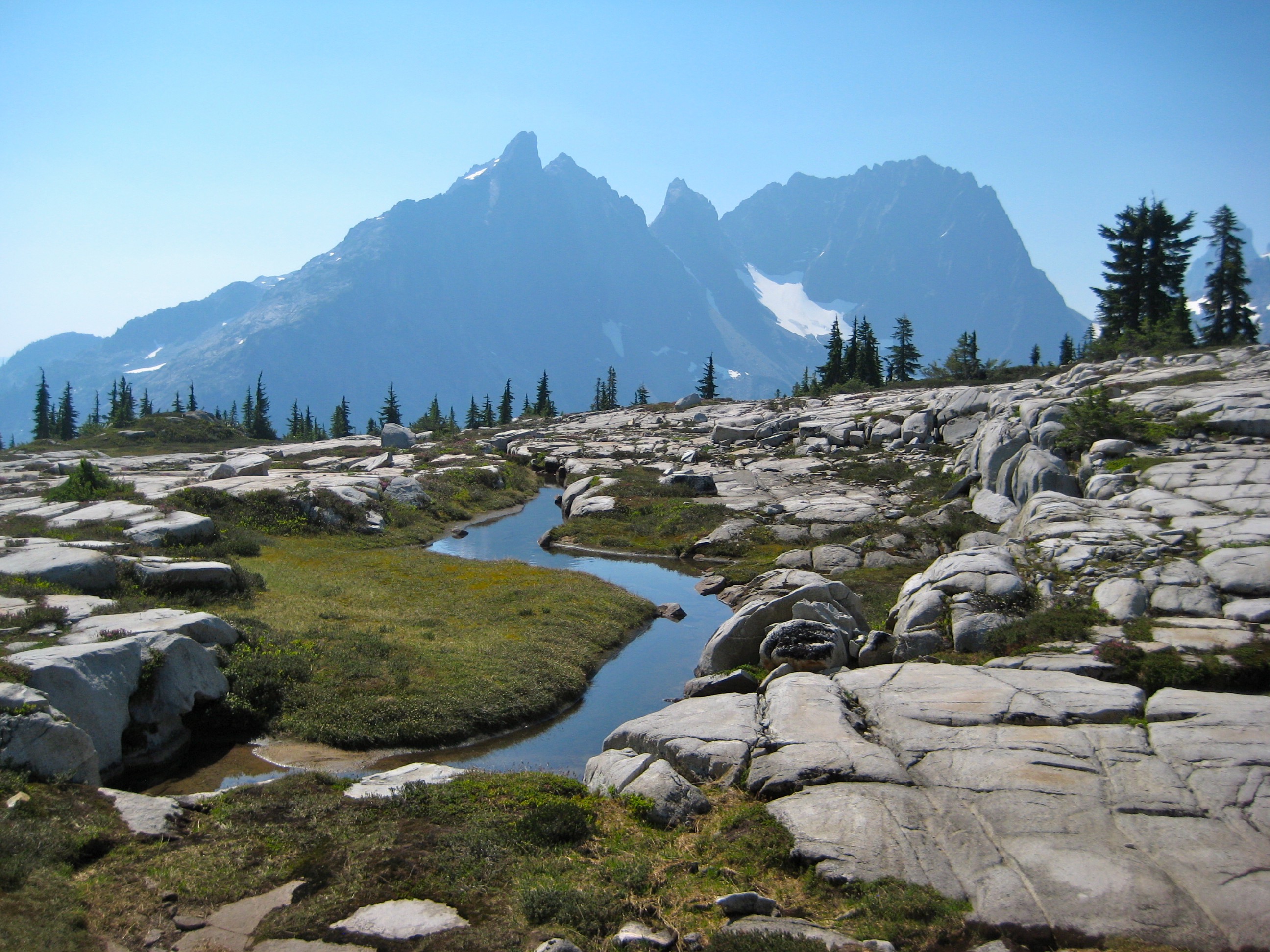 Little Big Chief Peak and Summit Chief Mountain in the Alpine Lakes Wilderness with high meadow creek and granite rock slabs in the Snoqualmie Mountains