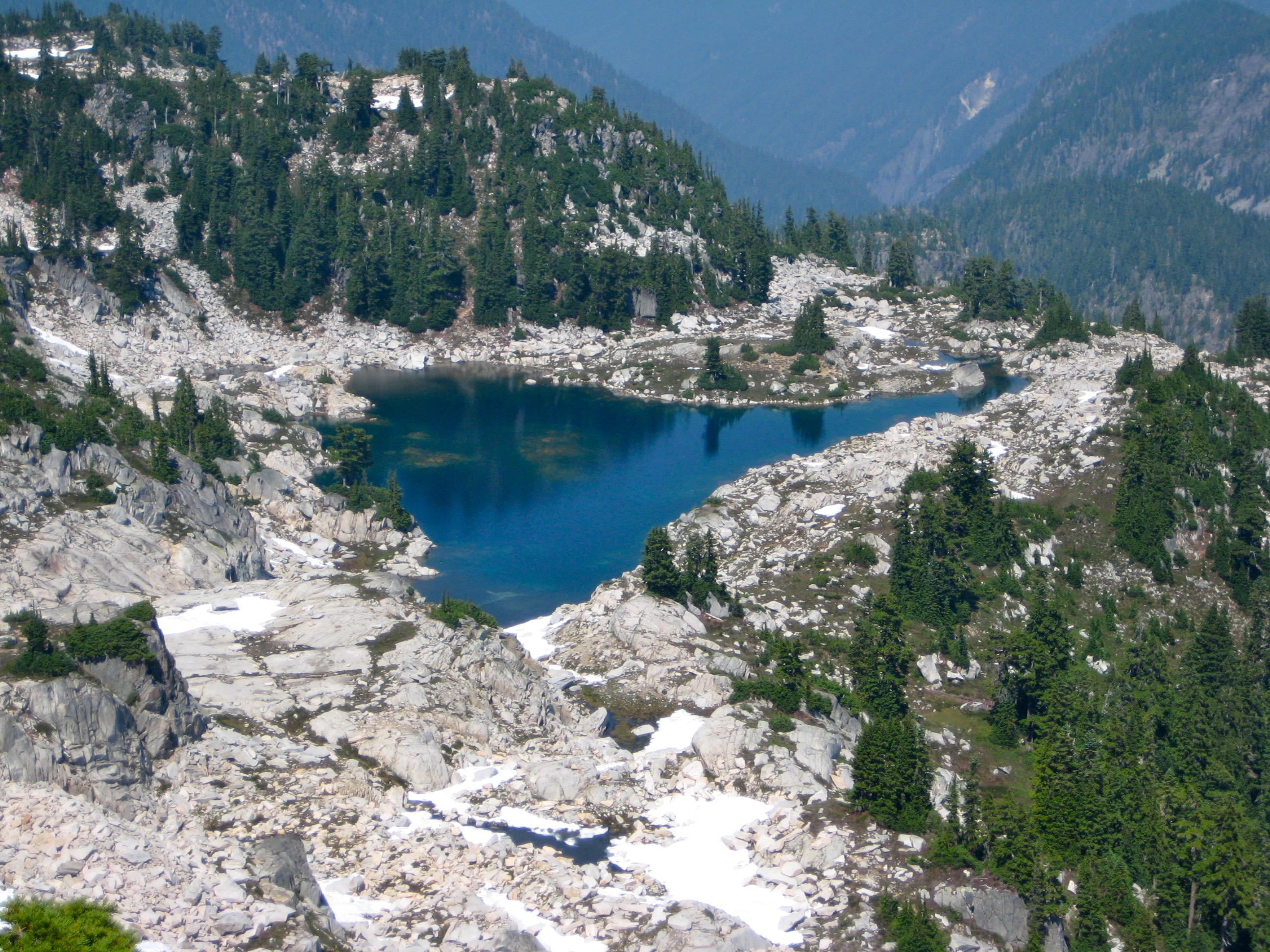 looking down on Tahl Lake in the Snoqualmie Mountains with granite slab shoreline