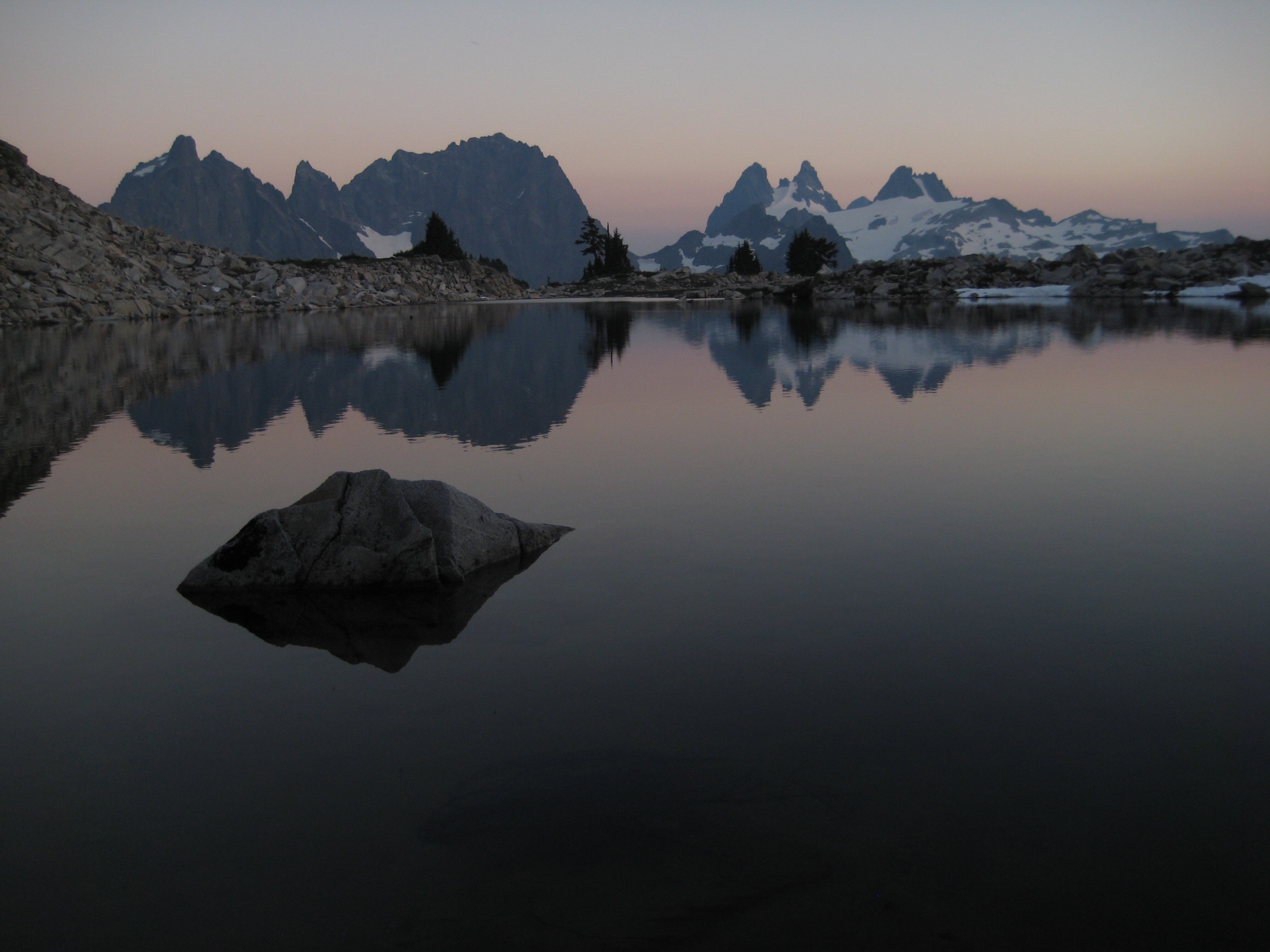 evening light on Little Big Chief Peak, Summit Chief Mountain, and Chimney Rock in the Snoqualmie Mountains with their reflection in Tank Lake in the Alpine Lakes Wilderness