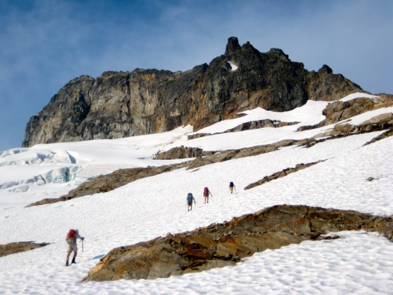 Mountain climbers ascend a glacier toward the summit of Sloan Peak