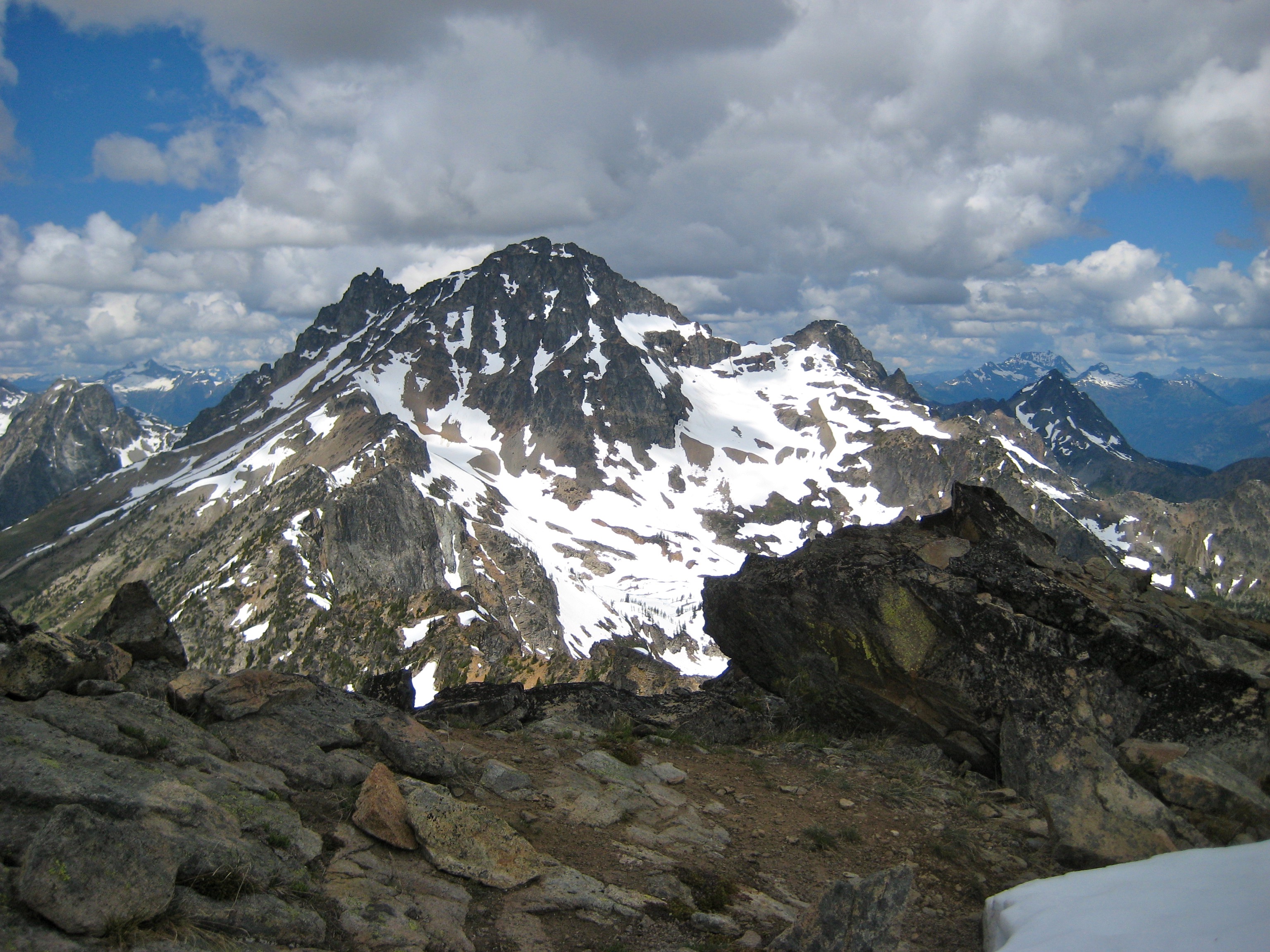 Black Peak with high clouds in the Ragged Ridge Mountains as seen from the summit of Corteo Peak in North Cascades National Park