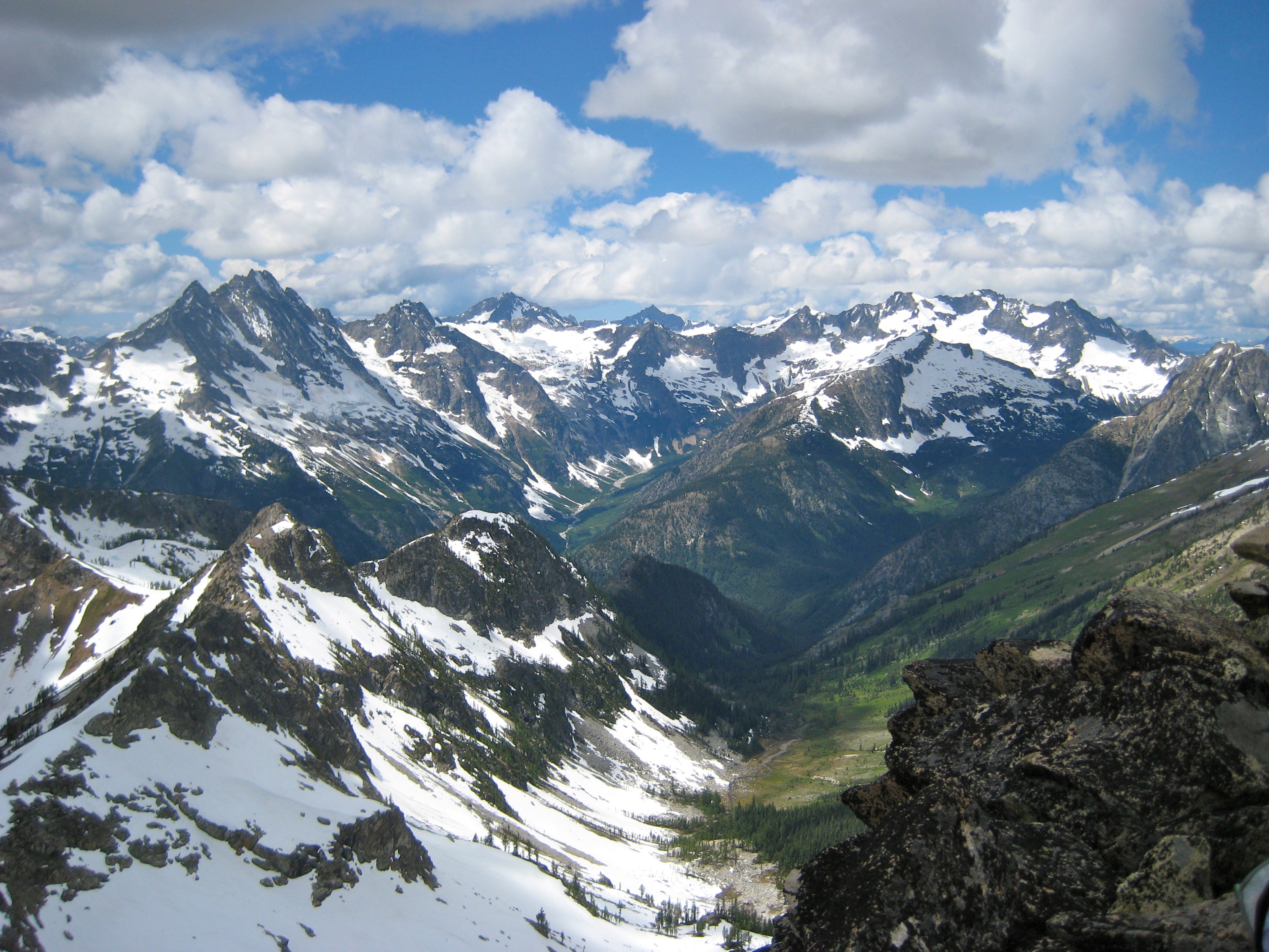 Mt Goode and Mt Logan with high clouds with the Ragged Ridge Mountains in the foreground as seen from the summit of Corteo Peak in North Cascades National Park