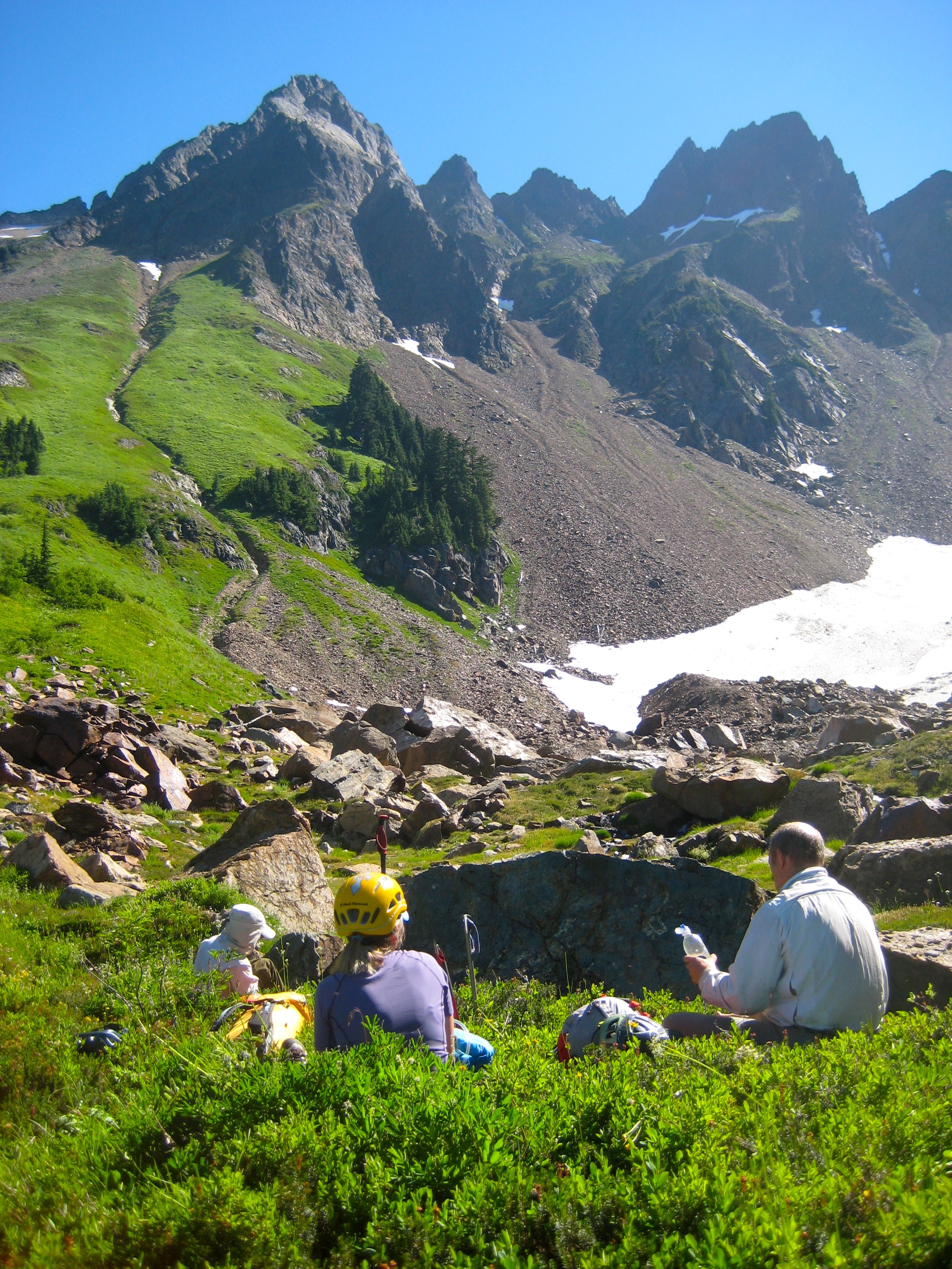 mountain climbers taking a break in the greenery with Mt Misch in the Glacier Peak Wilderness