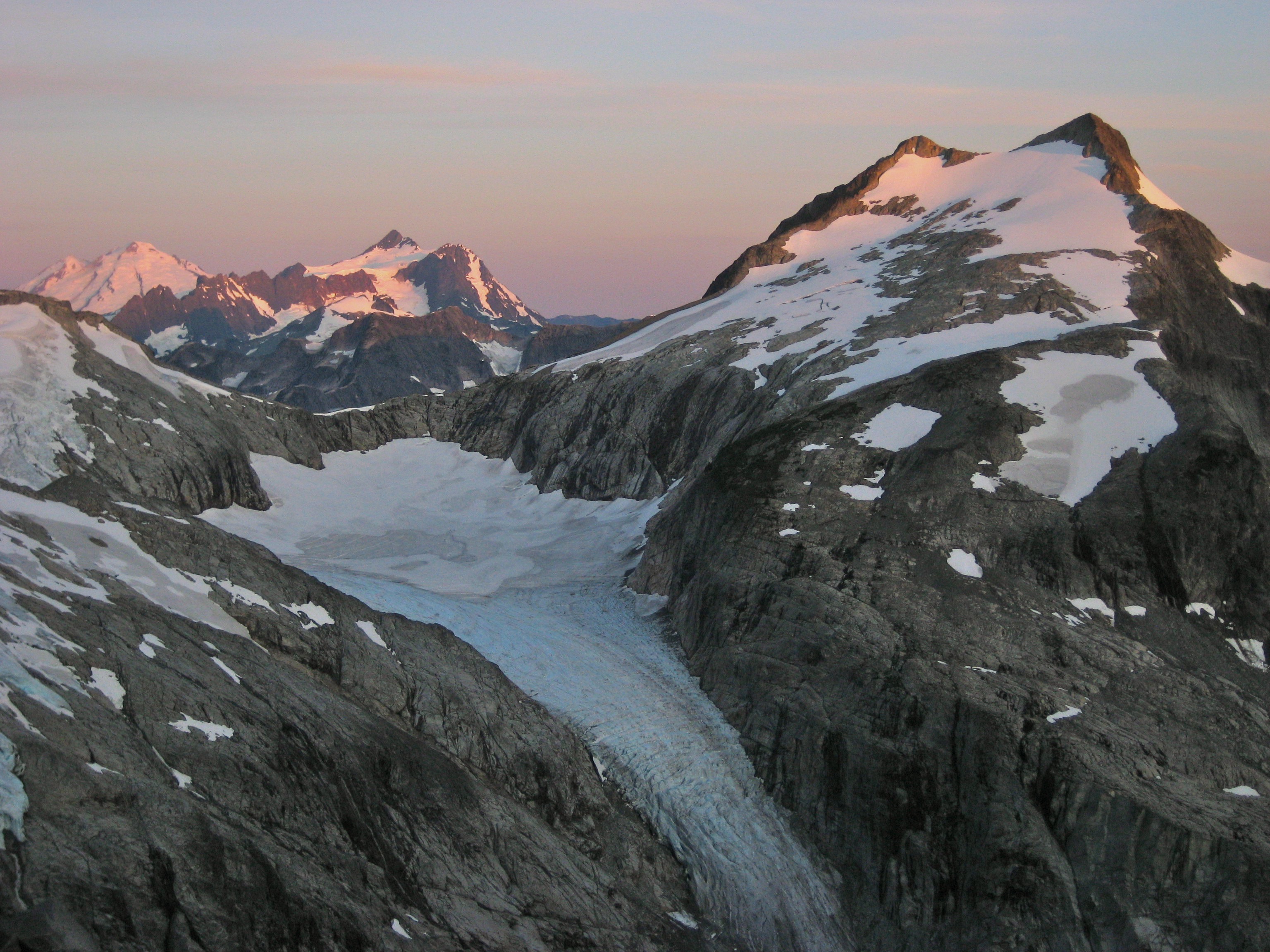 Sunrise on Mount Baker, Mount Shuksan, and Whatcom Peak from climbers camp on Mt Challenger moraine