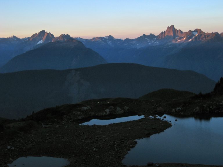 A row of rugged Chilliwack peaks lies on the skyline above Williamson Lake near Welch Peak