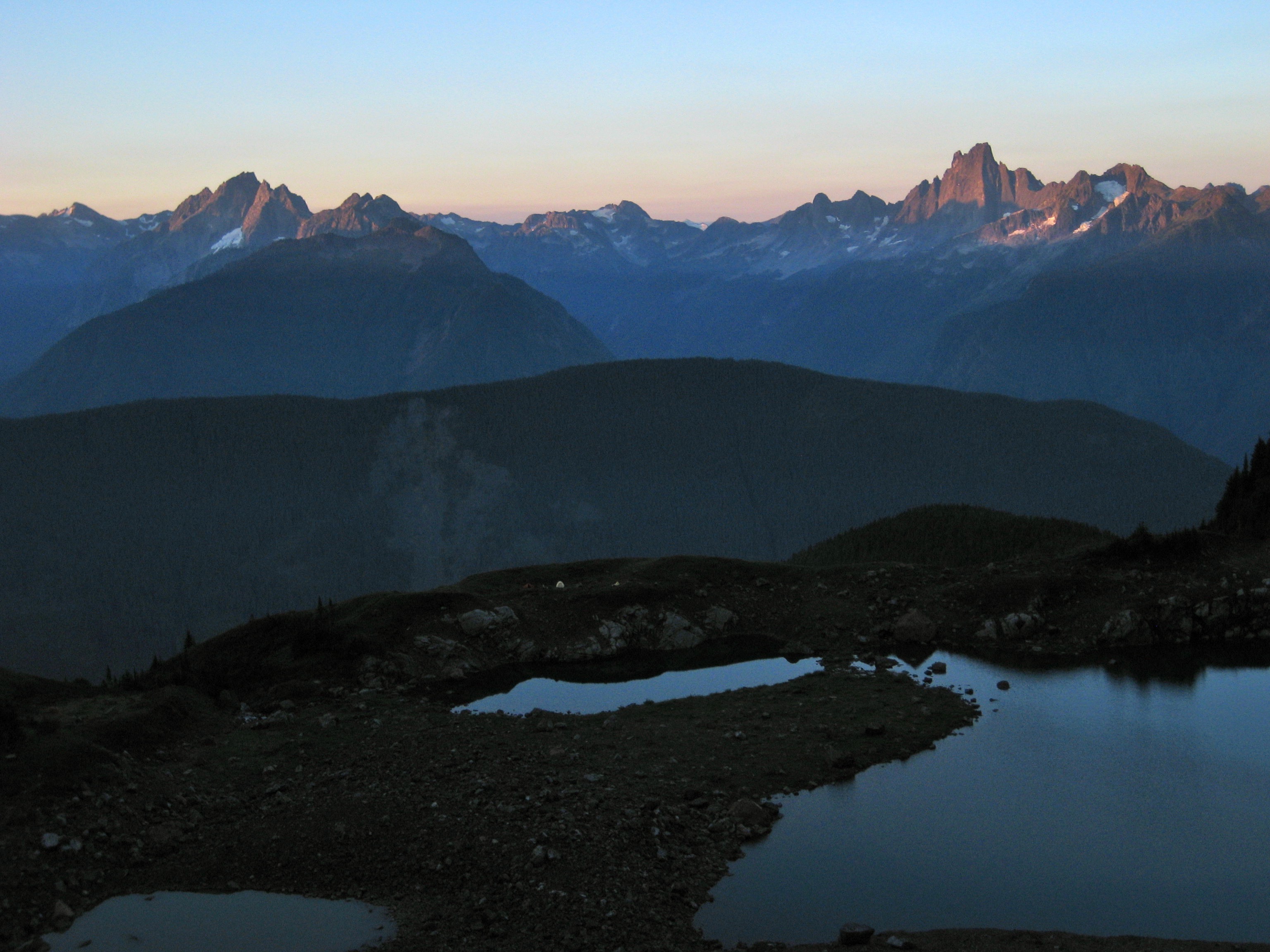 A row of rugged Chilliwack peaks lies on the skyline above Williamson Lake near Welch Peak