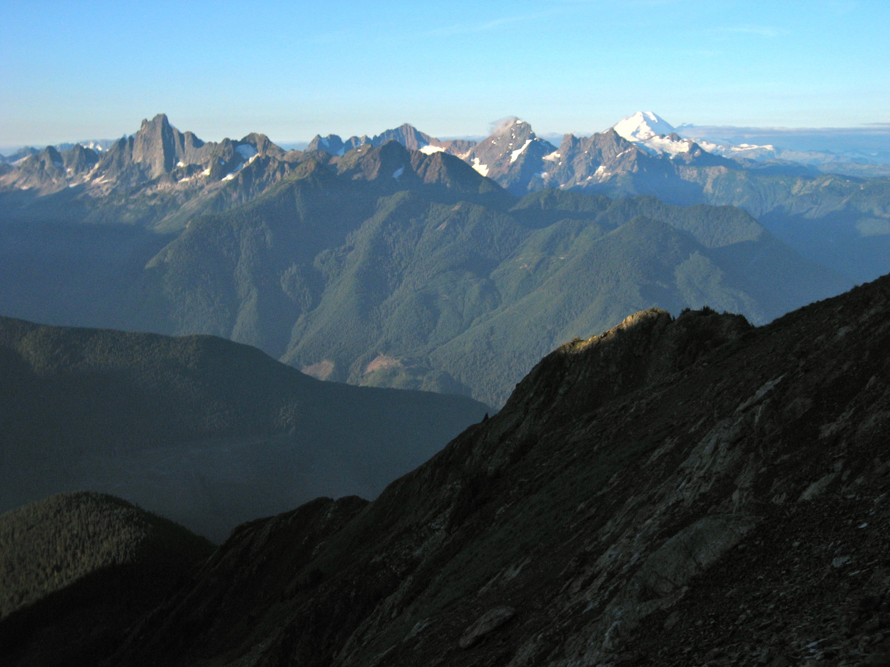 morning light on Mt Slesse, American Boarder Peak, and Mt Baker as seen from Williamson Lake in the Cheam Range