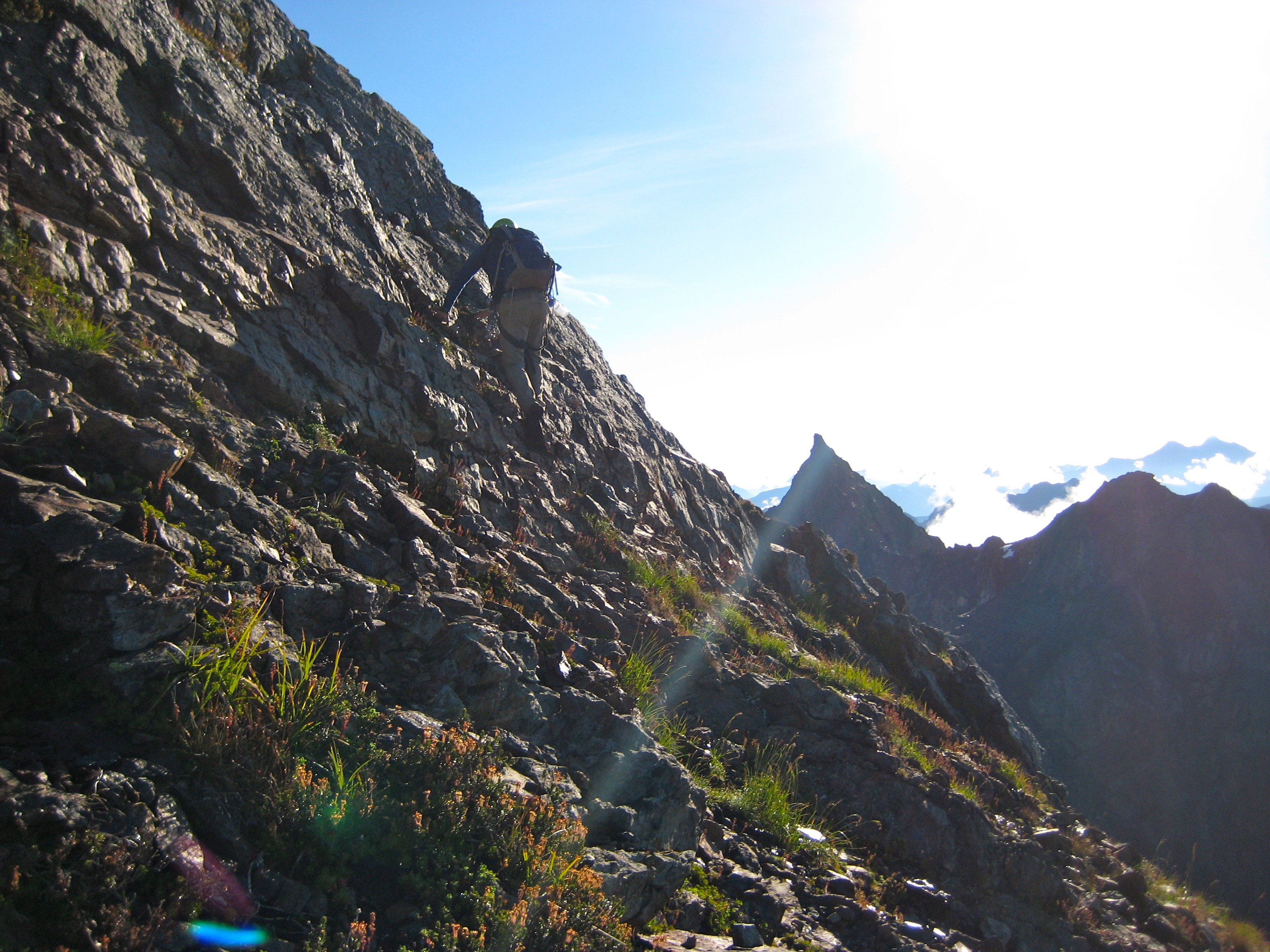 mountain climber scrambling up the steep, rocky south ridge of Welch Peak in the Cheam Range 