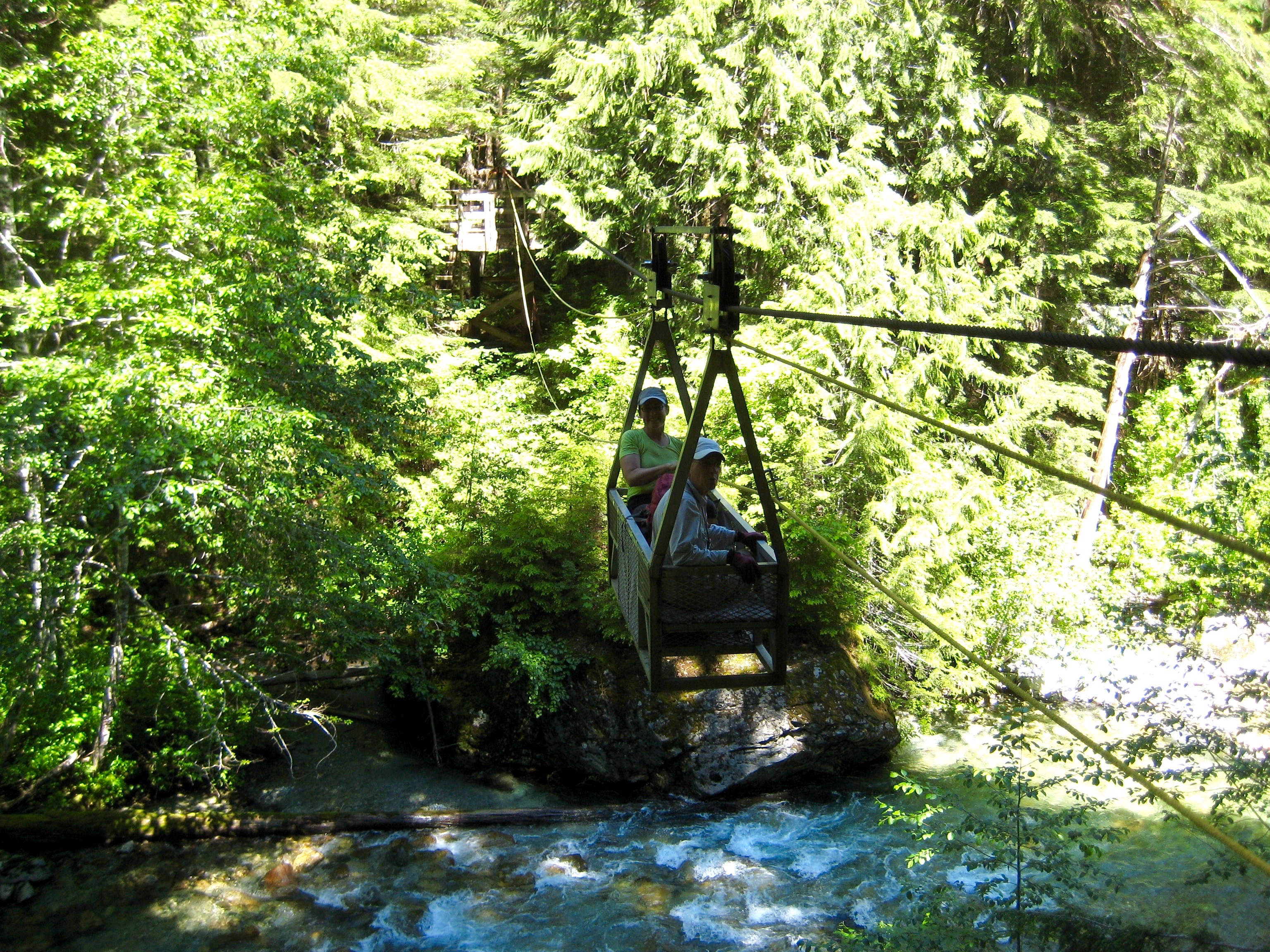 mountain climbers in manual cablecar crossing over Chilliwack River