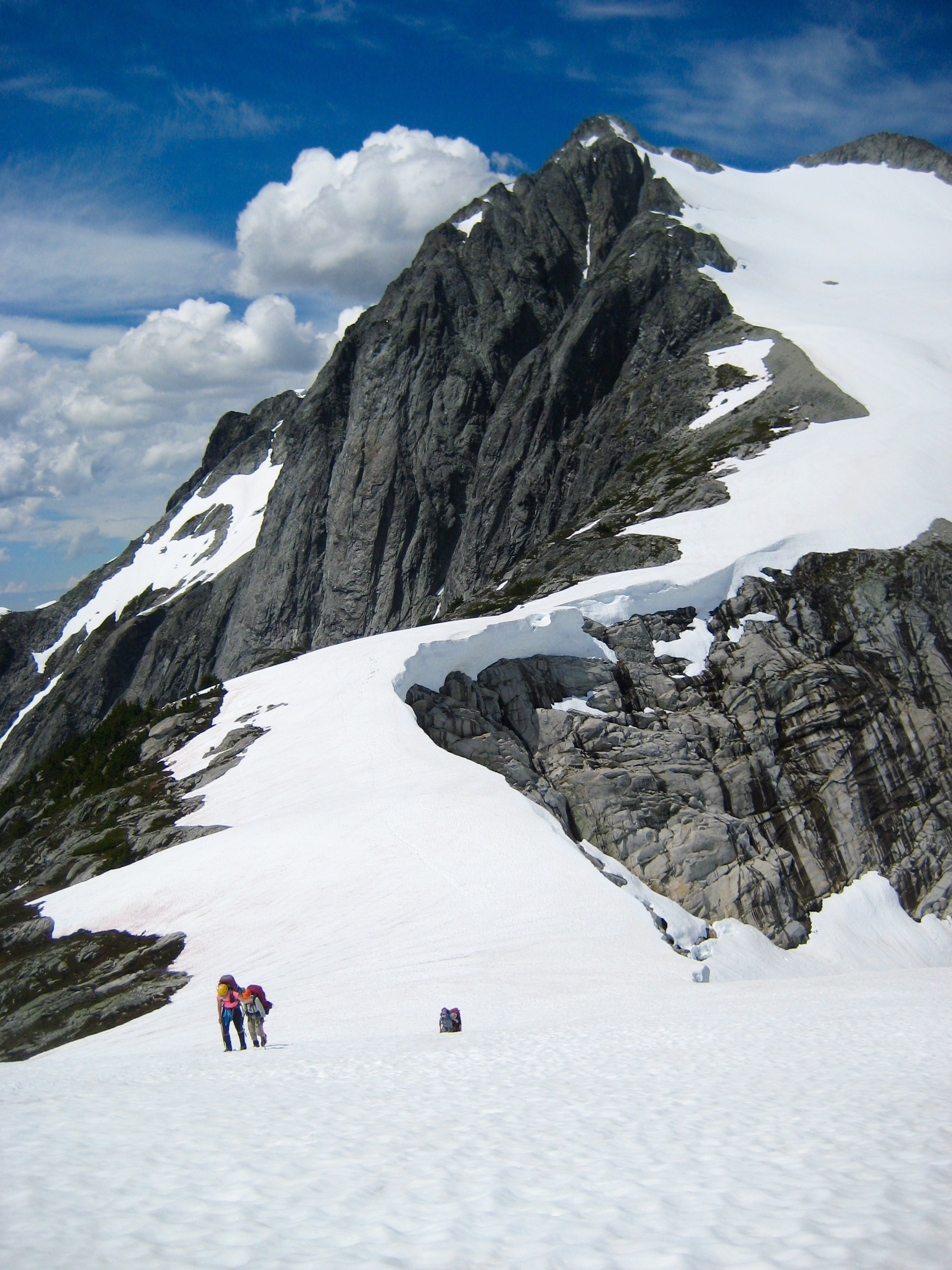 mountain climbers booting up snow covered Perfect Pass with Whatcom Peak in the background