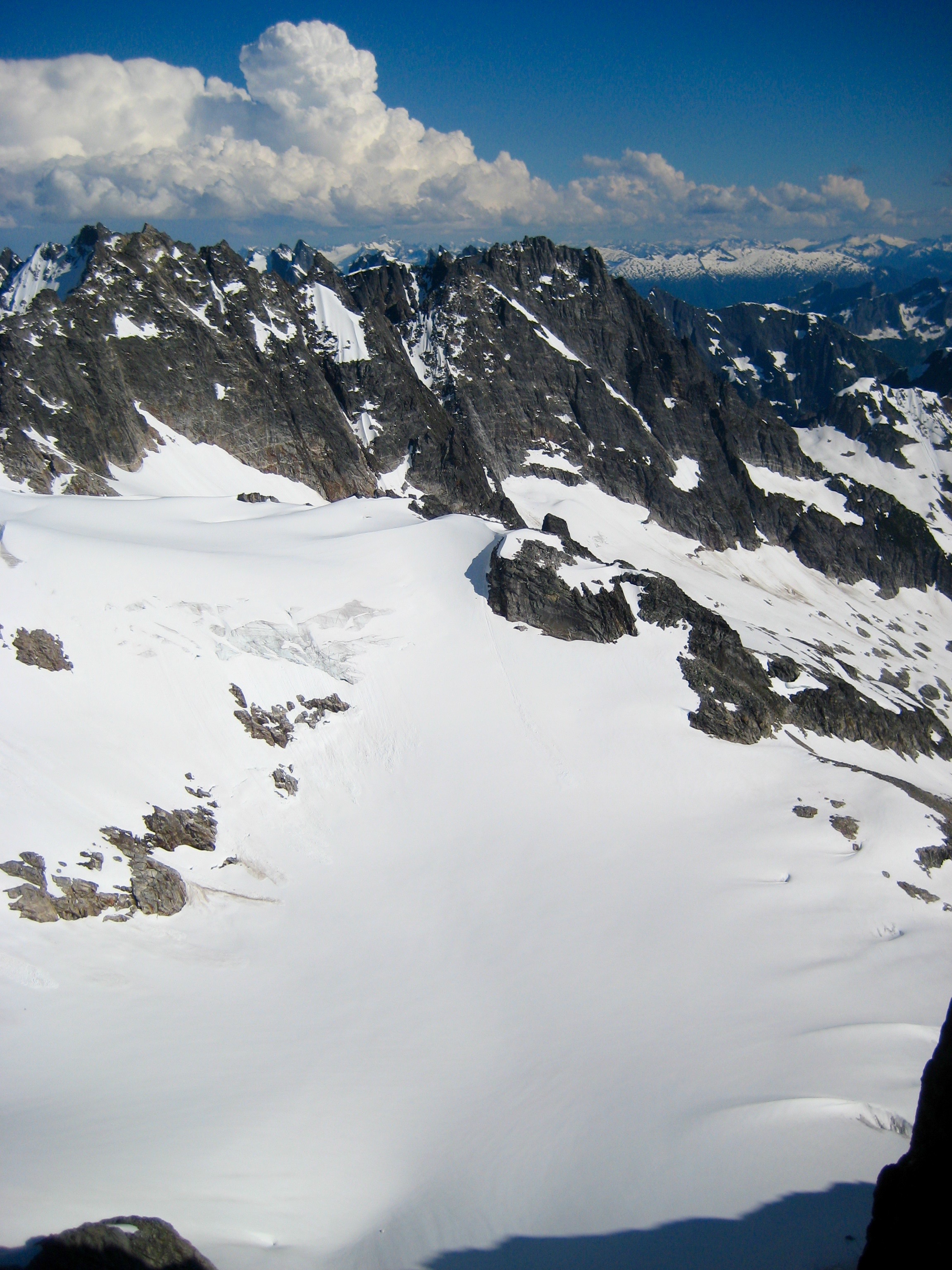 Crooked Thumb Peak and Phantom Peak with a snowy basin from the summit of West Challenger Peak in the Northern Pickets