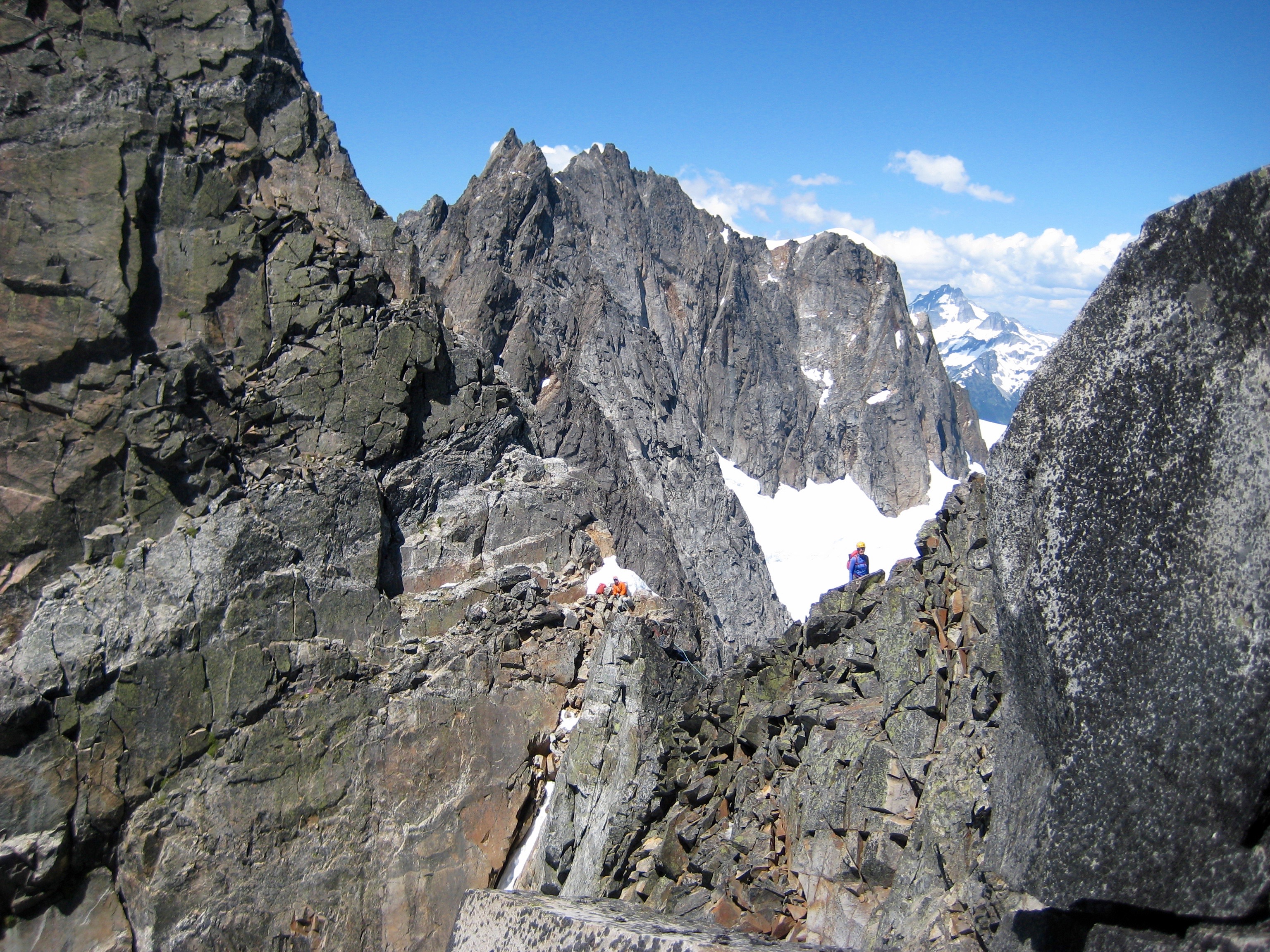 mountain climbers scrambling around rocky pinnacle on the north ridge of Crooked Thumb Peak