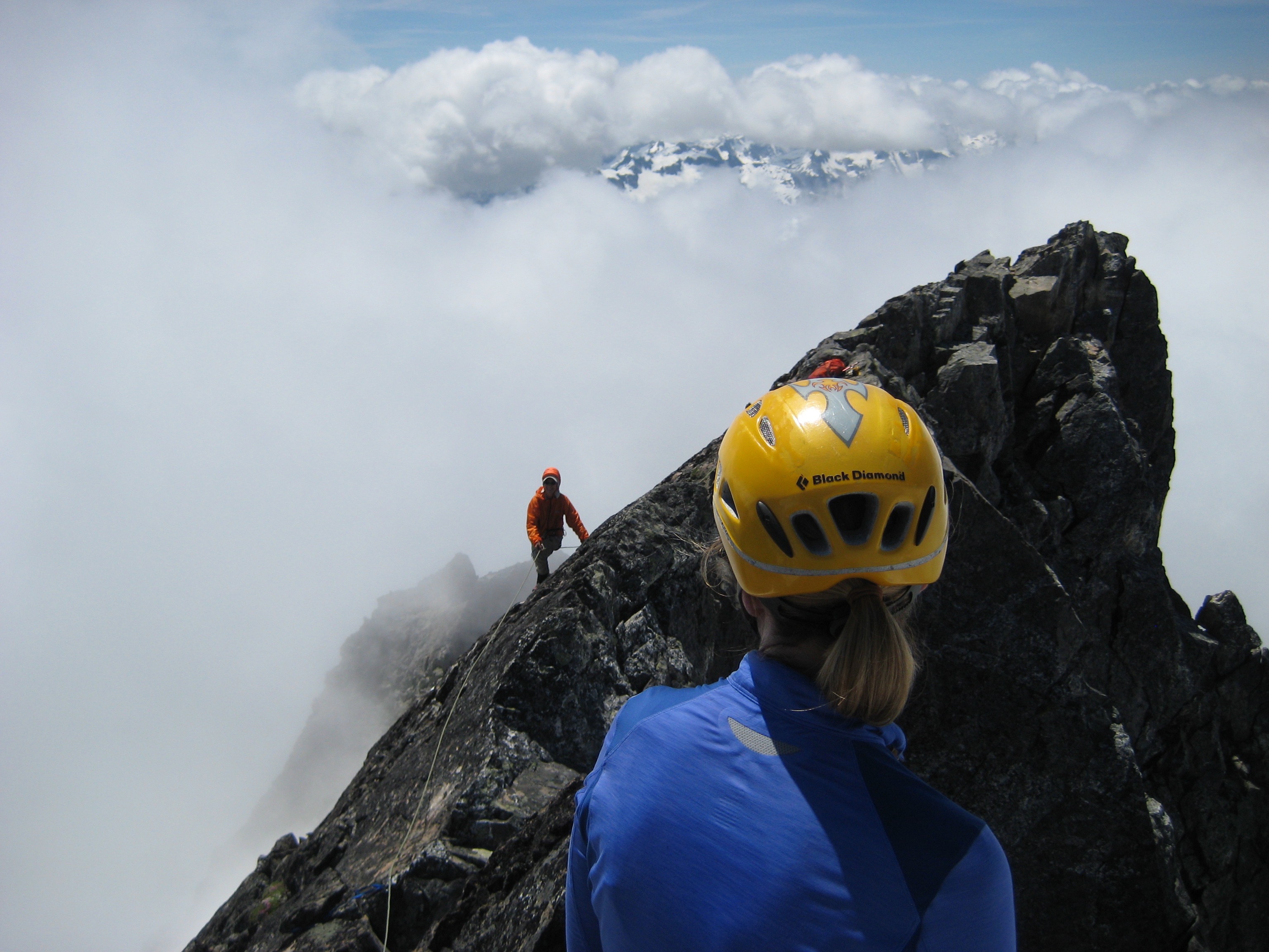 mountain climber scrambling the last section of rock leading to the summit of Phantom Peak in the Northern Pickets