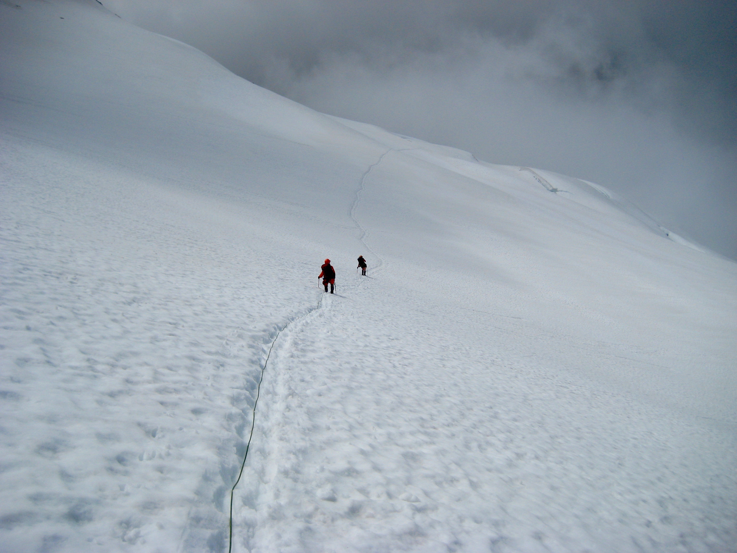 mountain climbers plunge stepping down Challenger Glacier into the fog