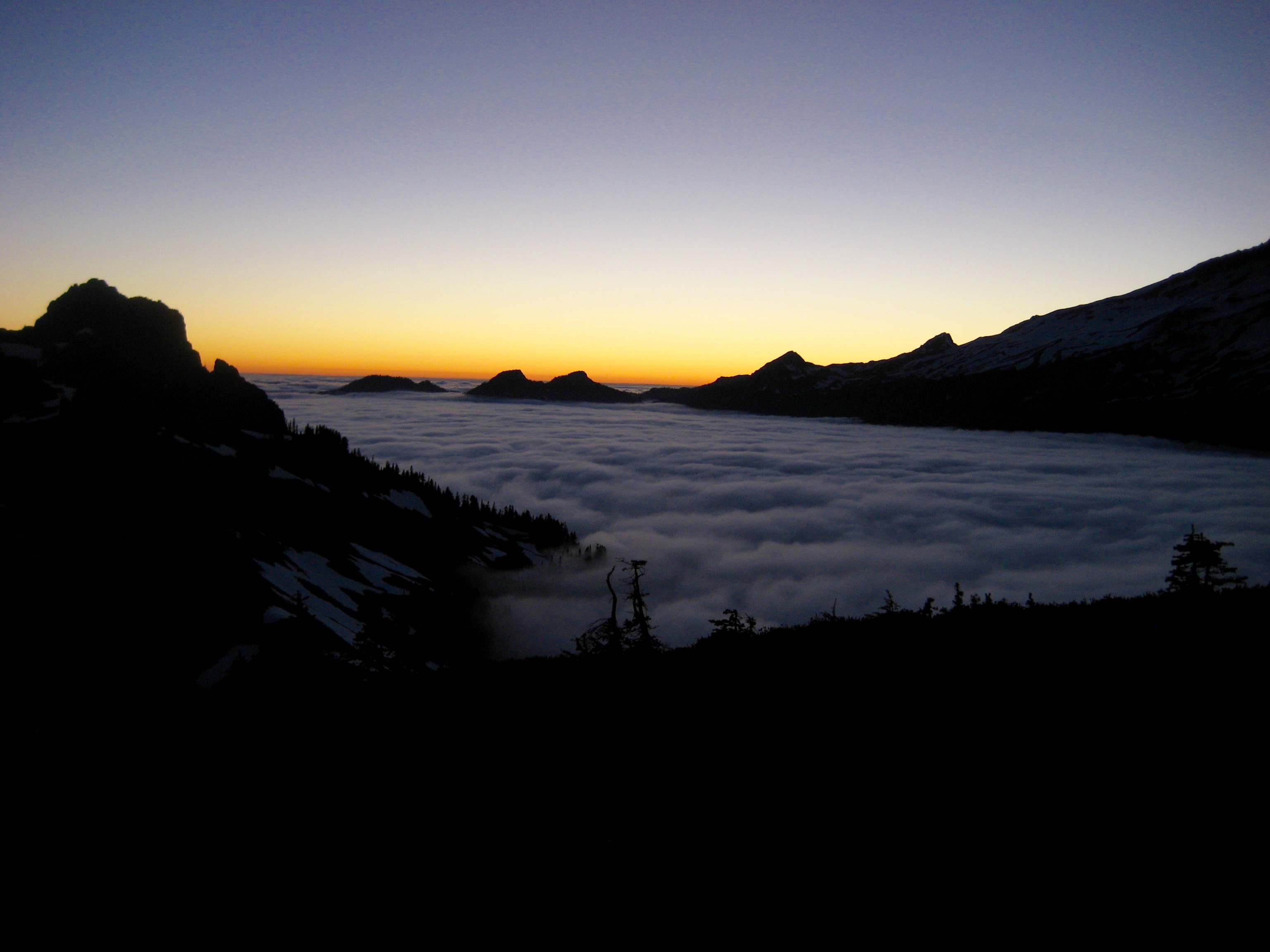 sunset on mountain ridge with valley fog in Mt Rainier National Park 