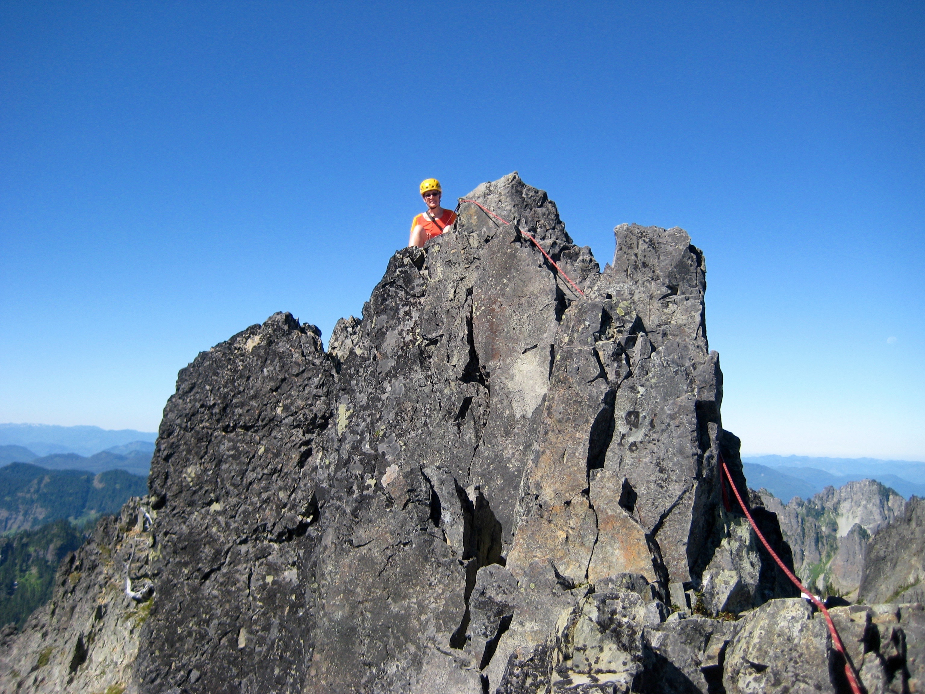mountain climber on the summit rock horn of The Castle in the Tatoosh Range in Mt Rainier National Park 