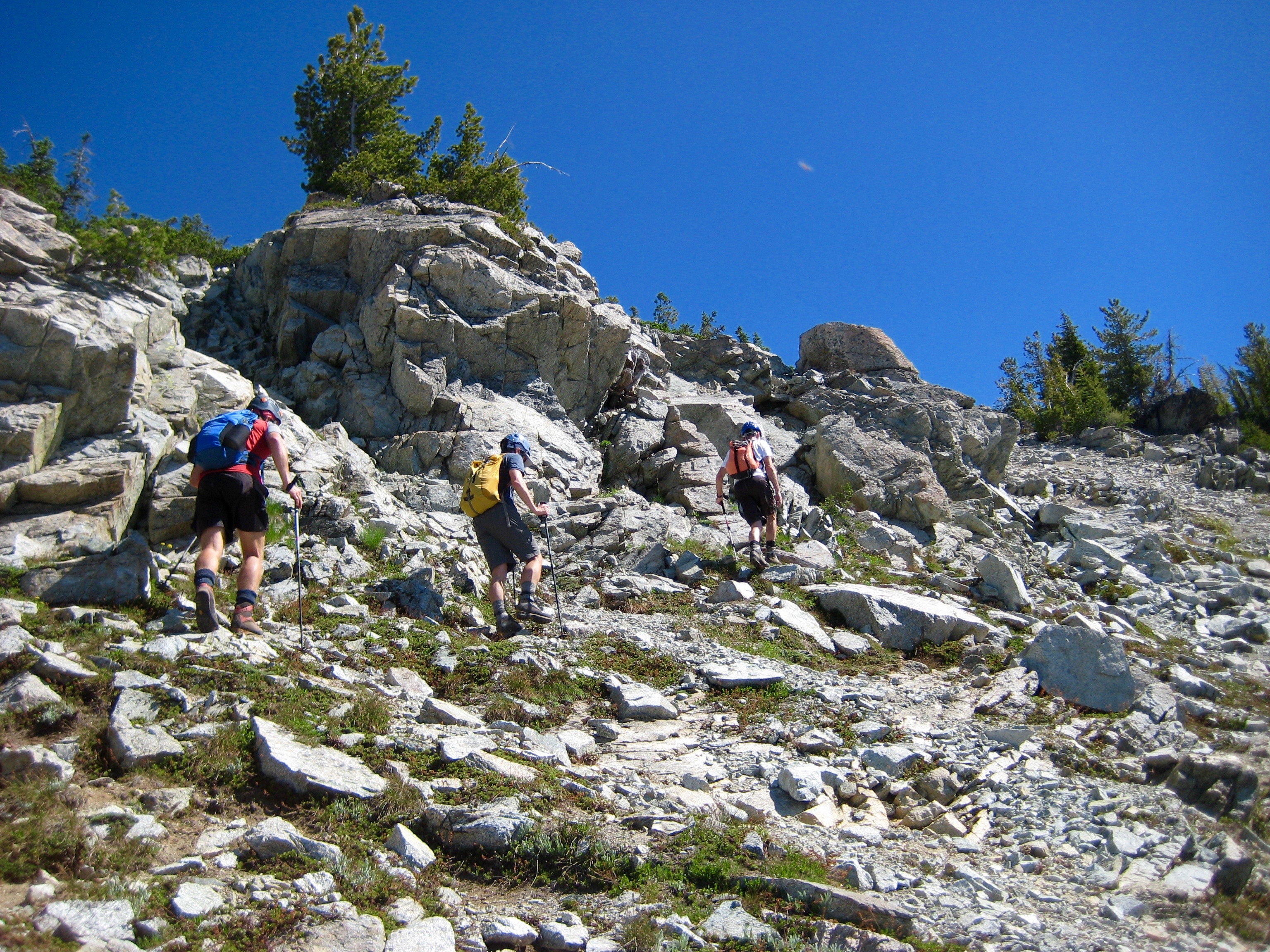mountain climbers scrambling rock and heather hillside of Bowan Mountain in the Stehekin Mountains