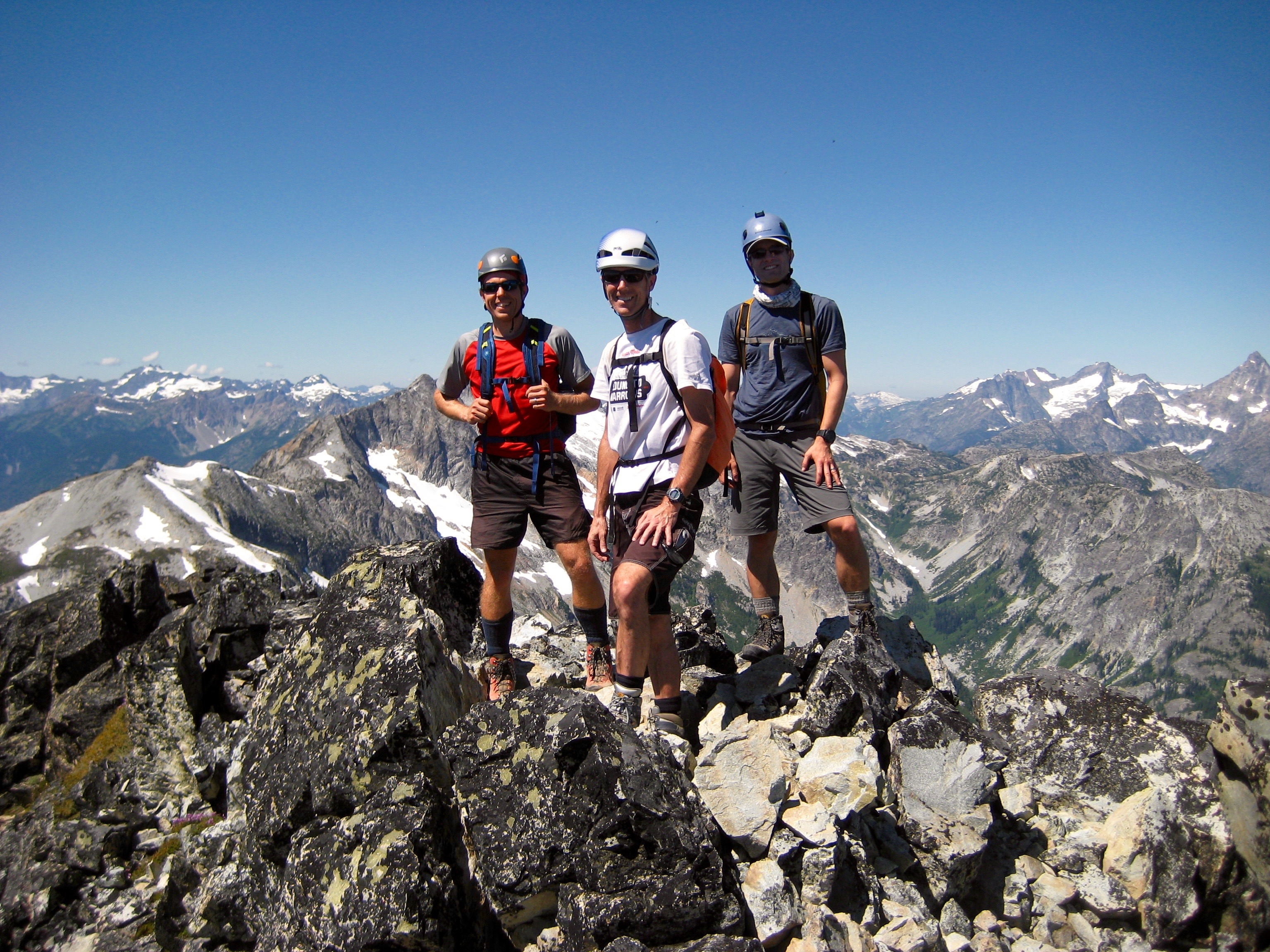 mountain climbers standing on the rocky summit of Bowan Mountain with the Stehekin Mountains in the background