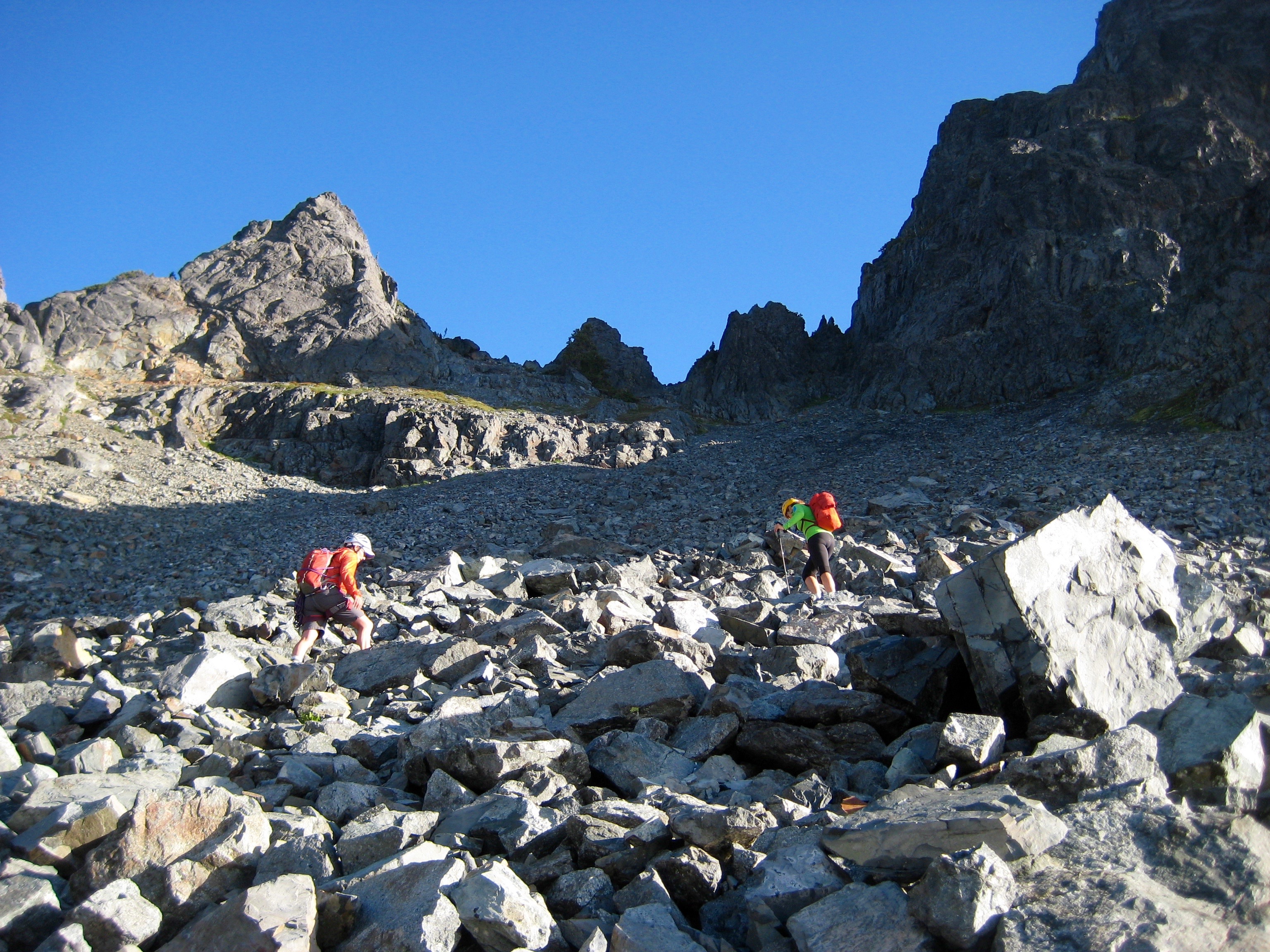 mountain climbers ascending boulder field heading toward west ridge notch on Mt Thomson in the Snoqualmie Mountains