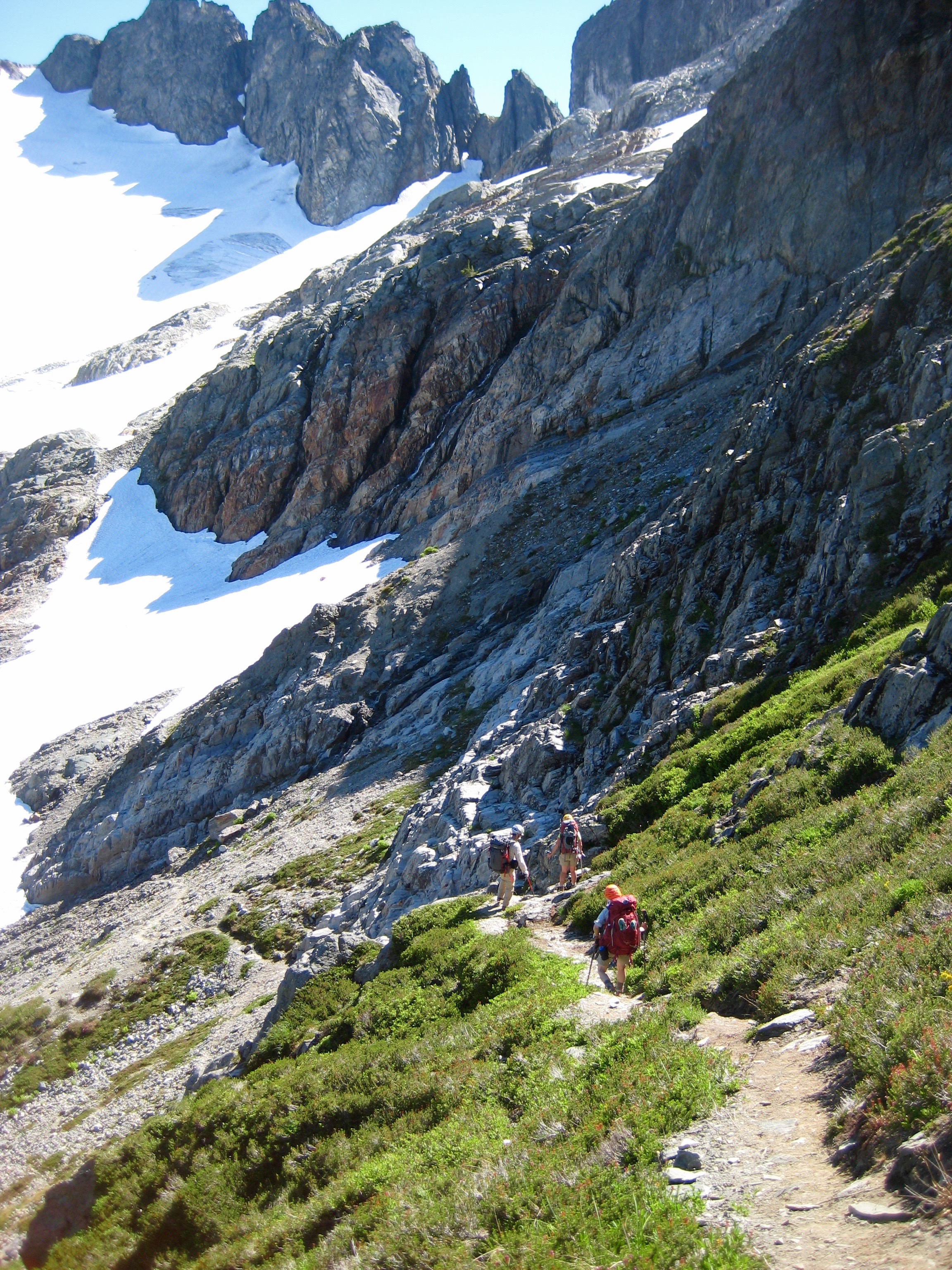 mountain climbers traversing trail toward snow slopes and Cache Glacier in North Cascades National Park on way to Johannesburg Mountain