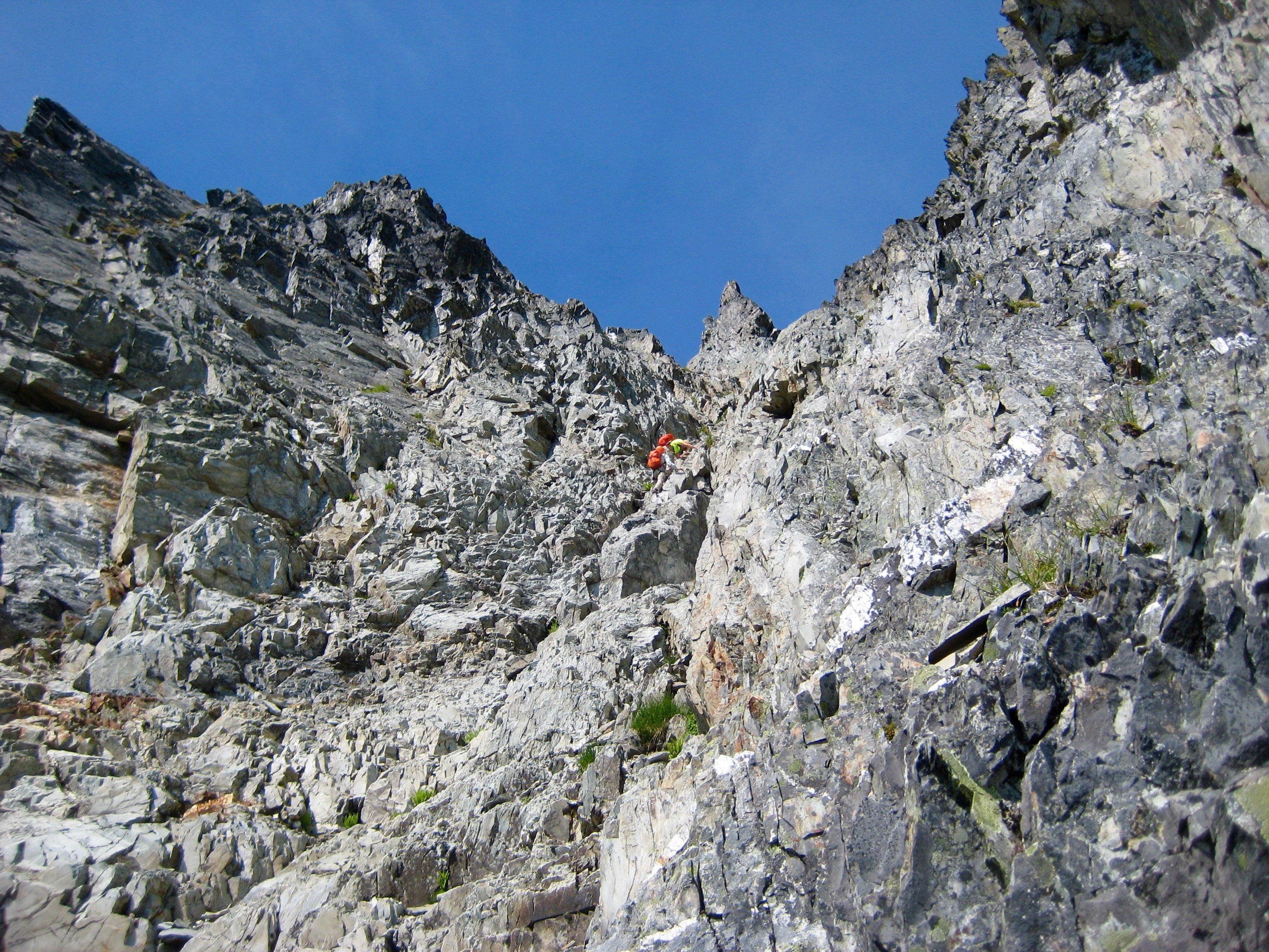 mountain climbers scrambling up the steep, loose, rock gully leading to the false summit of Johannesburg Mountain in North Cascades National Park