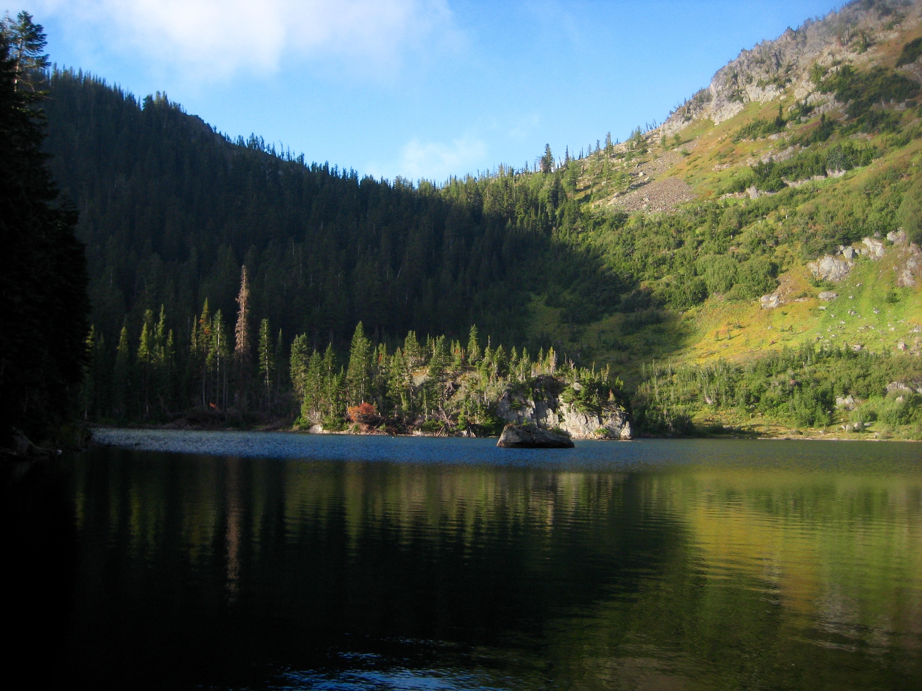 morning sun on an island in the middle of Lake Ethel with grren foliage along the Chiwaukum Traverse in the Alpine Lakes Wilderness