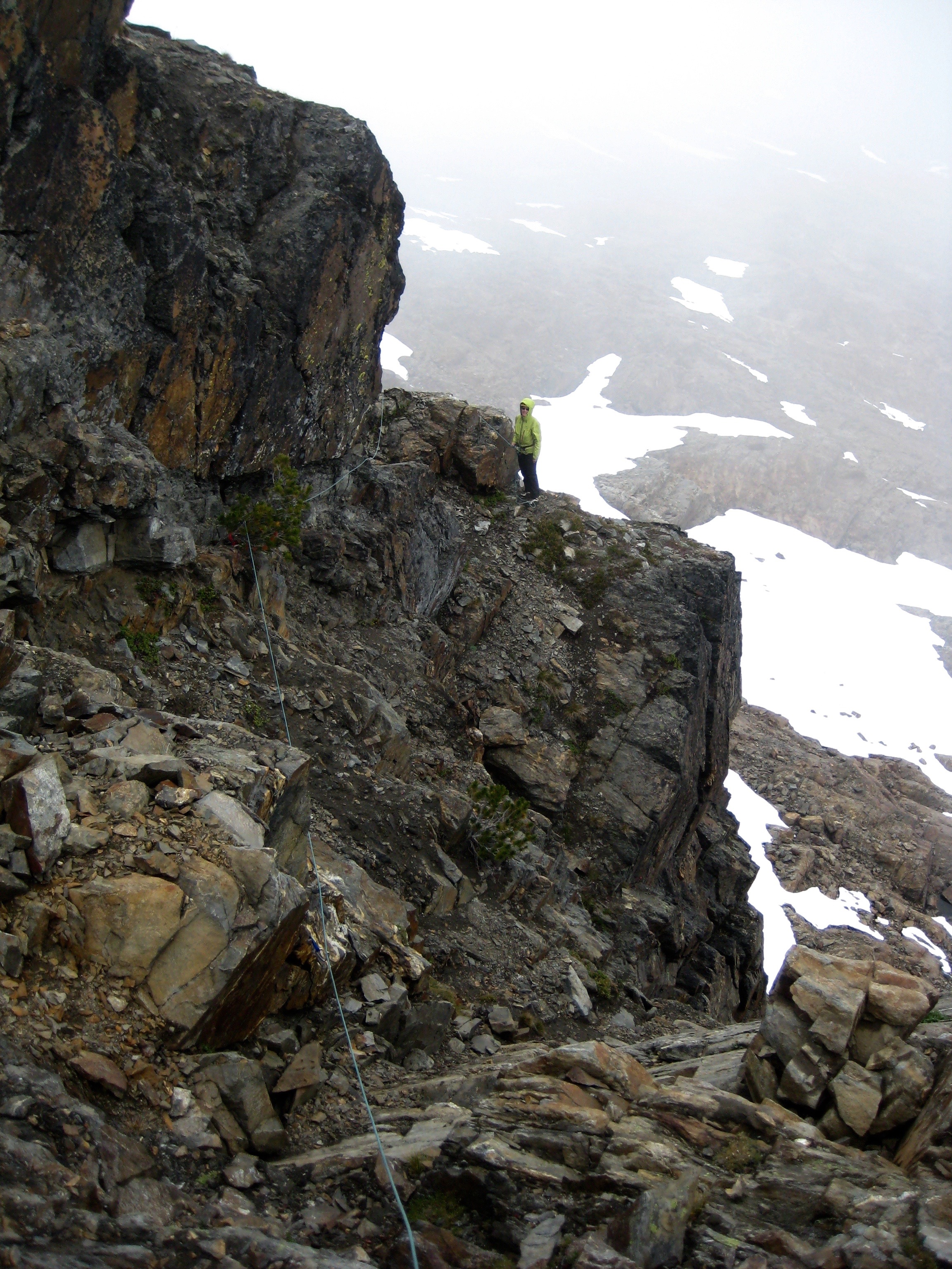roped mountain climber on exposed rocky ledge on the shoulder of Big Chiwaukum Peak in the Alpine Lakes Wilderness 