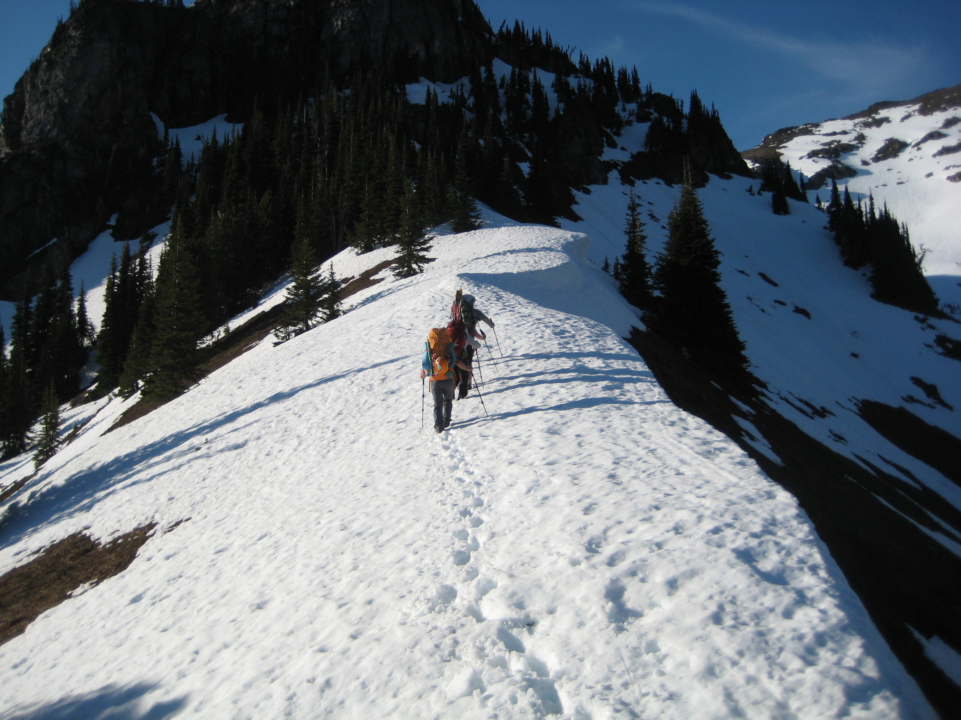 mountain climbers hiking snowy ridge heading to the ridge of Silvertip Mountain in the Sumallo Mountains BC Canada