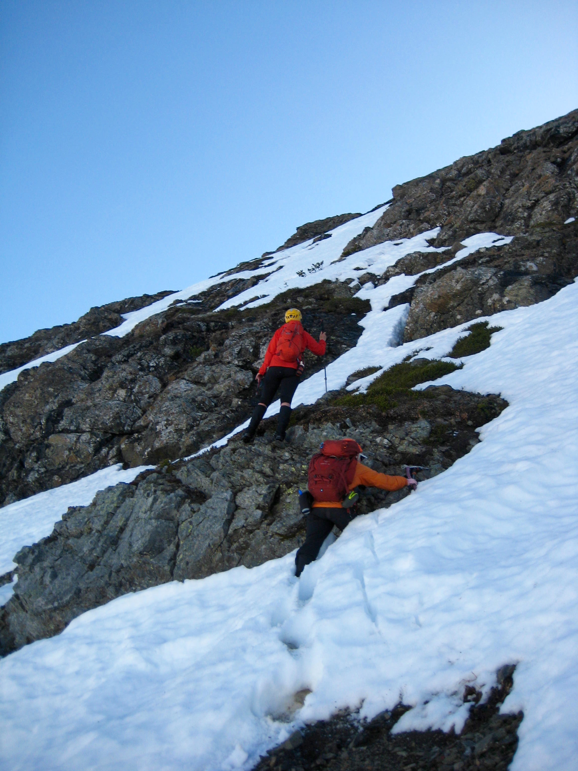 mountain climbers working up soft snow and exposed boulders on Mt RIdeout in the Sumallo Mountains BC Canada