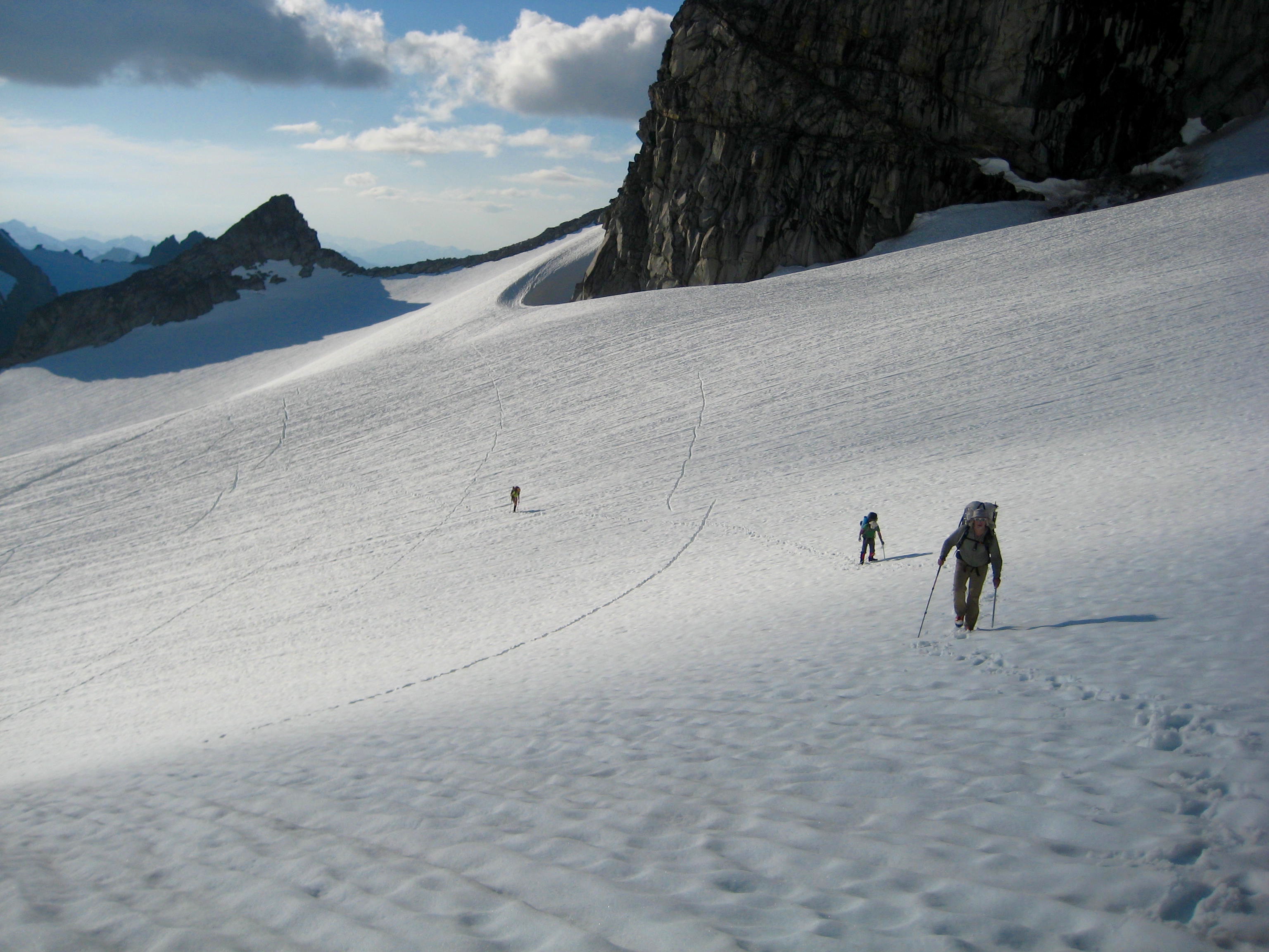 looking down on mountain climbers traversing the Dome Glacier below the Dana-Dome Saddle in the Ptarmigan Mountains