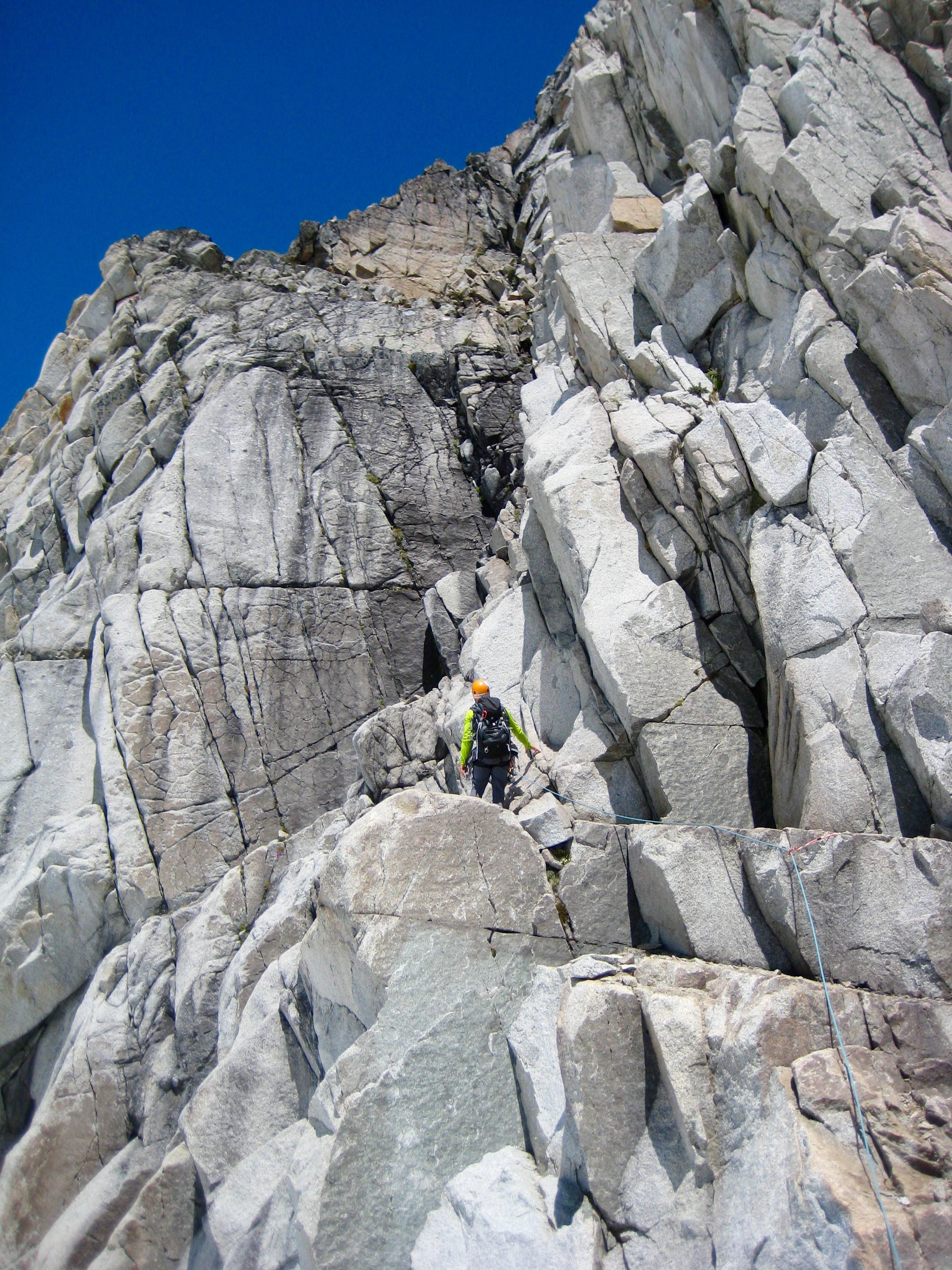 roped mountain climber scrambling steep rock face of Gunsight Peak in the Glacier Peak Wilderness