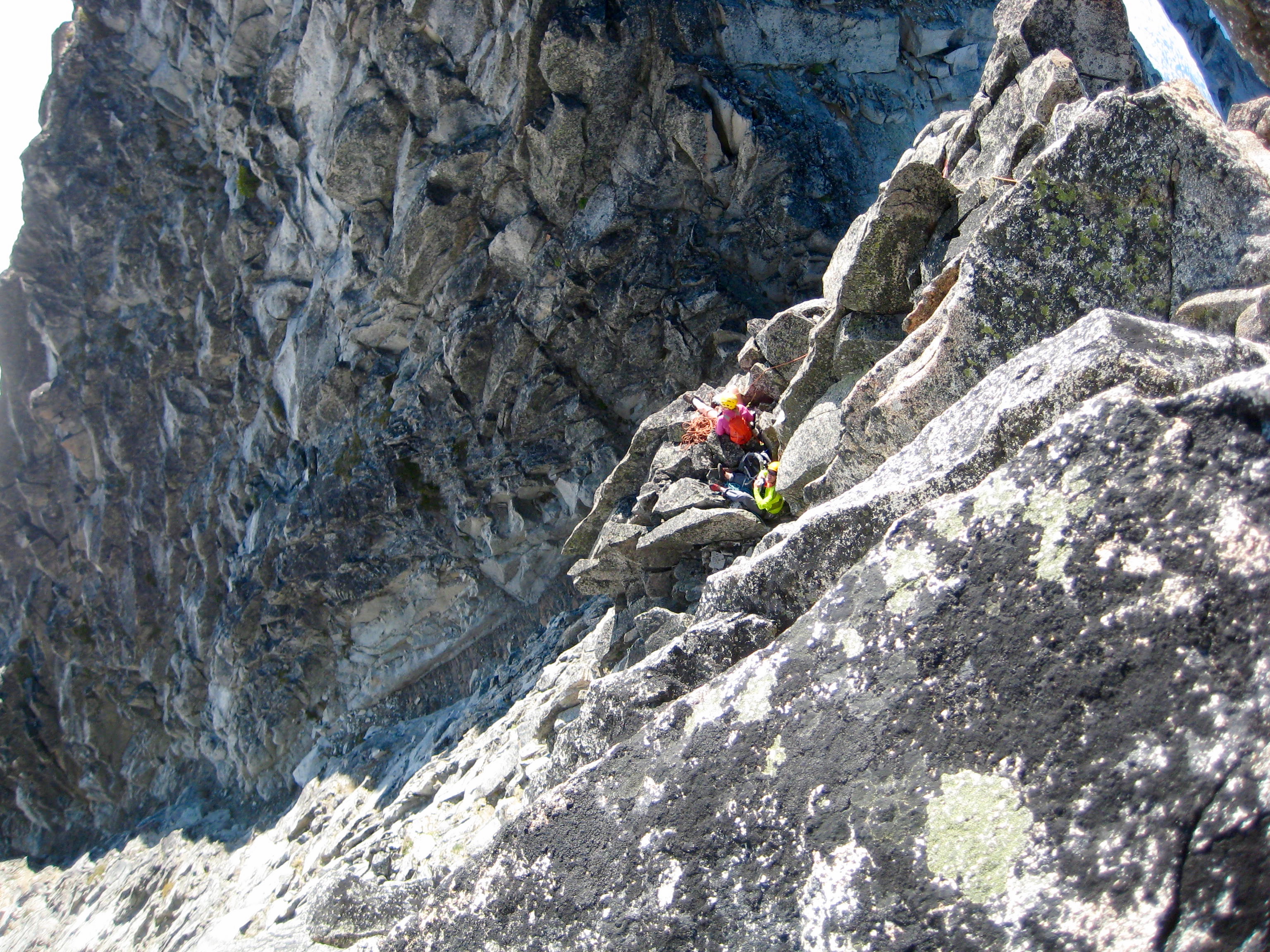 looking down steep rock face from upper belay station on Gunsight Peak in the Glacier Peak WIlderness