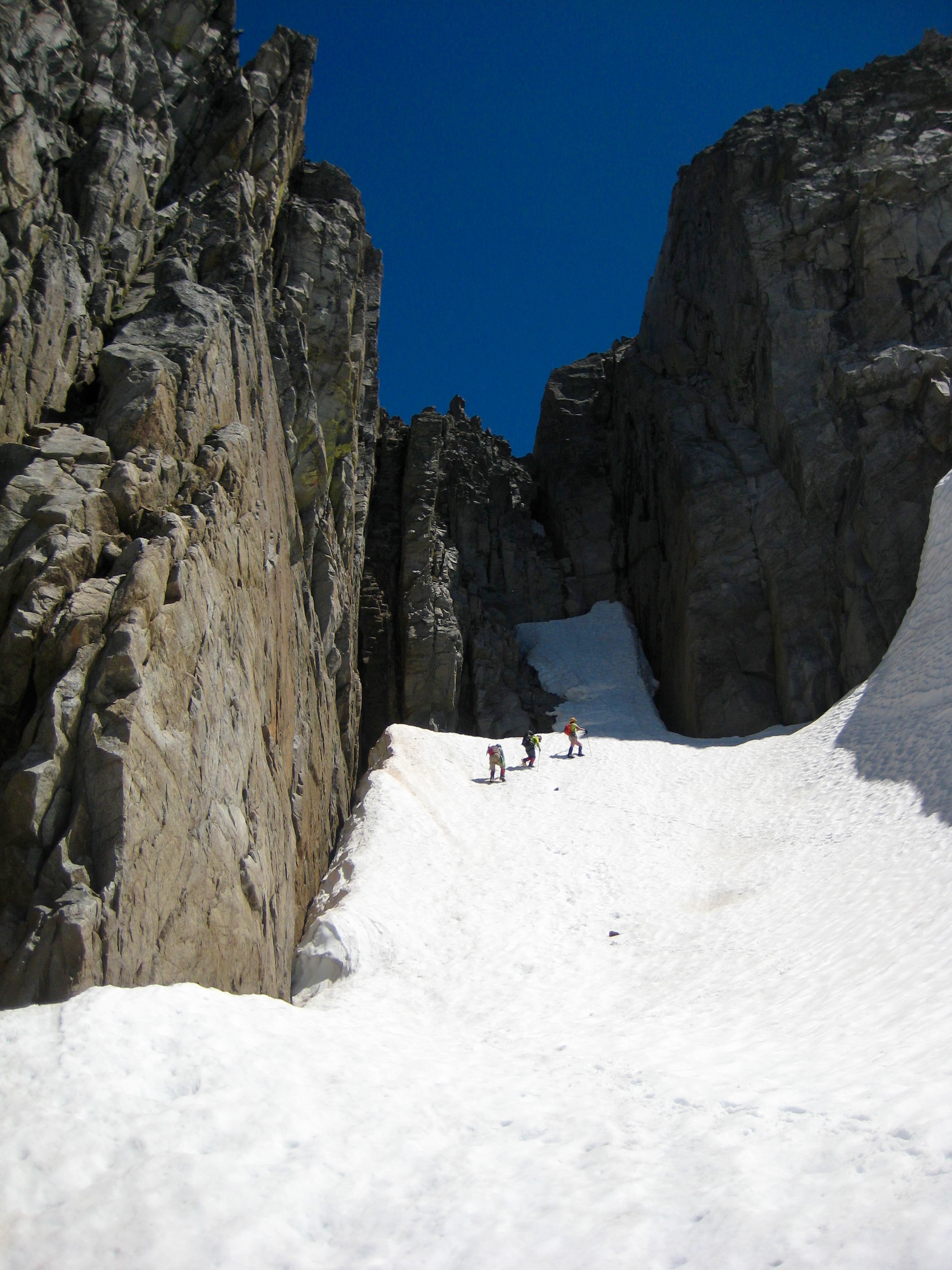 mountain climbers booting up snow chute under the West Ridge chimney of Sinister Peak in the Glacier Peak Wilderness