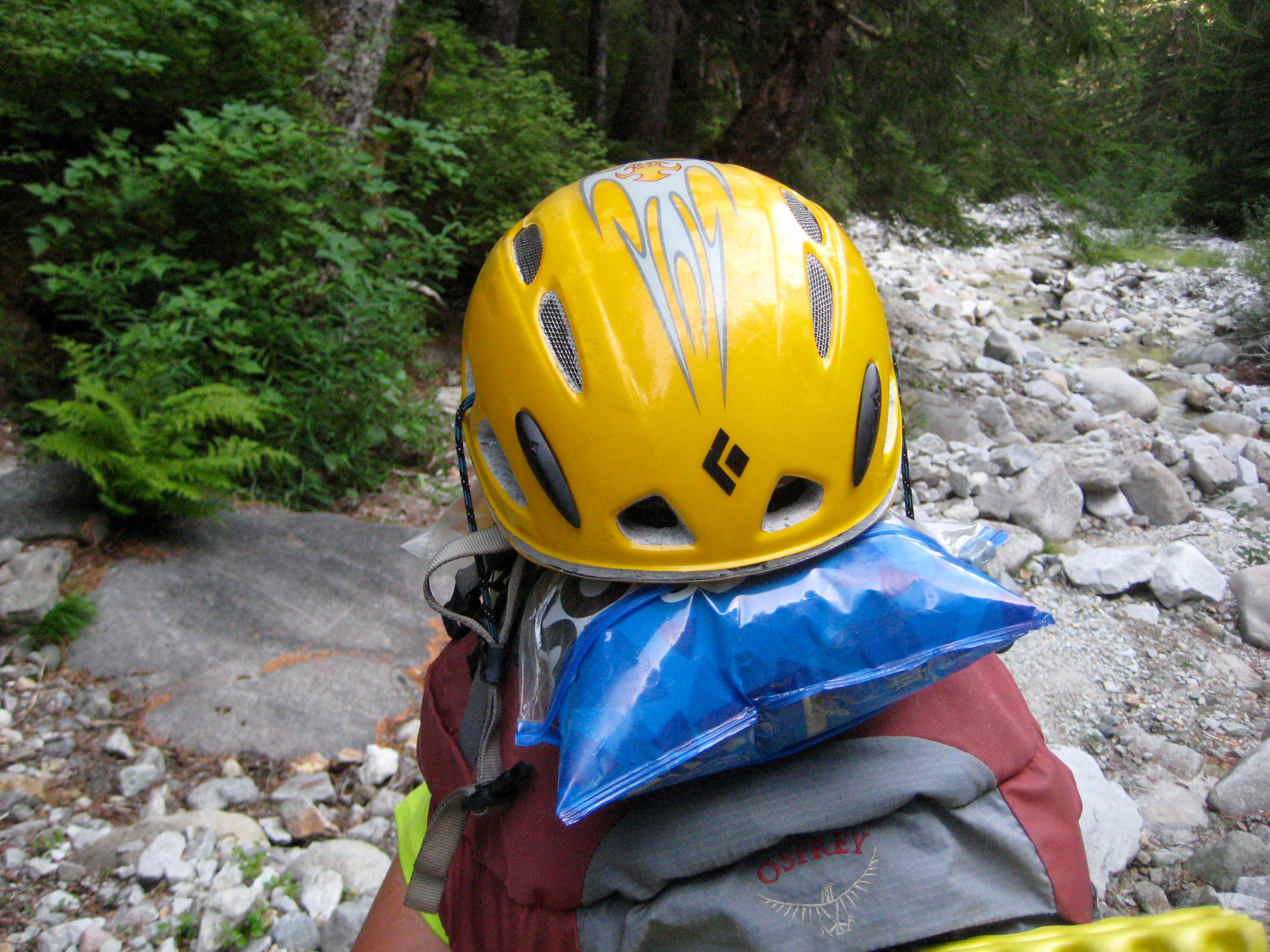mountain climber helmet attached to mountain climbers backpack