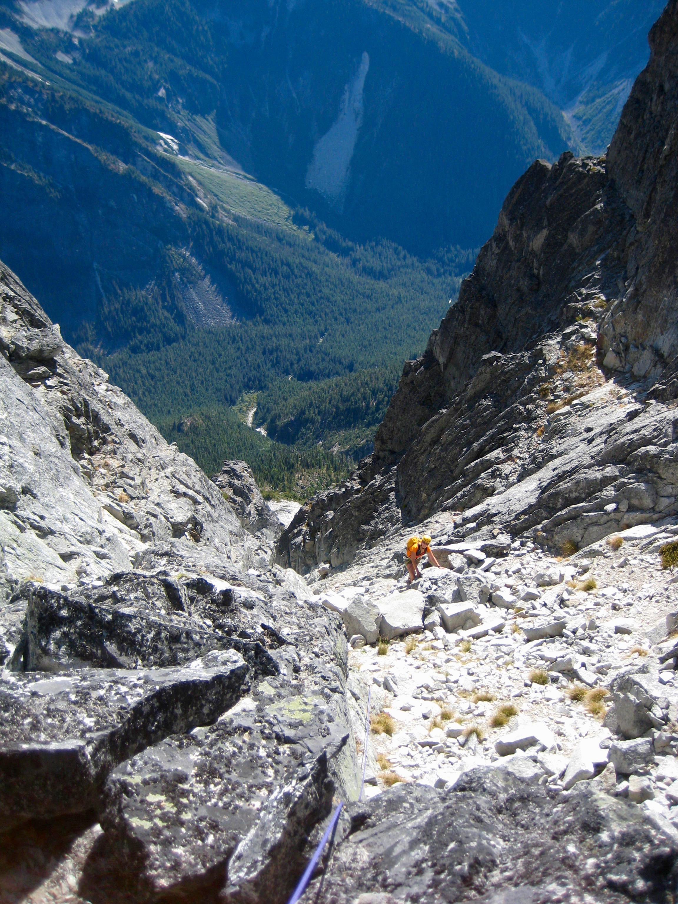 mountain climber scrambling the boulder field in the summit notch of Bear Mountain in the American Chilliwack Mountains