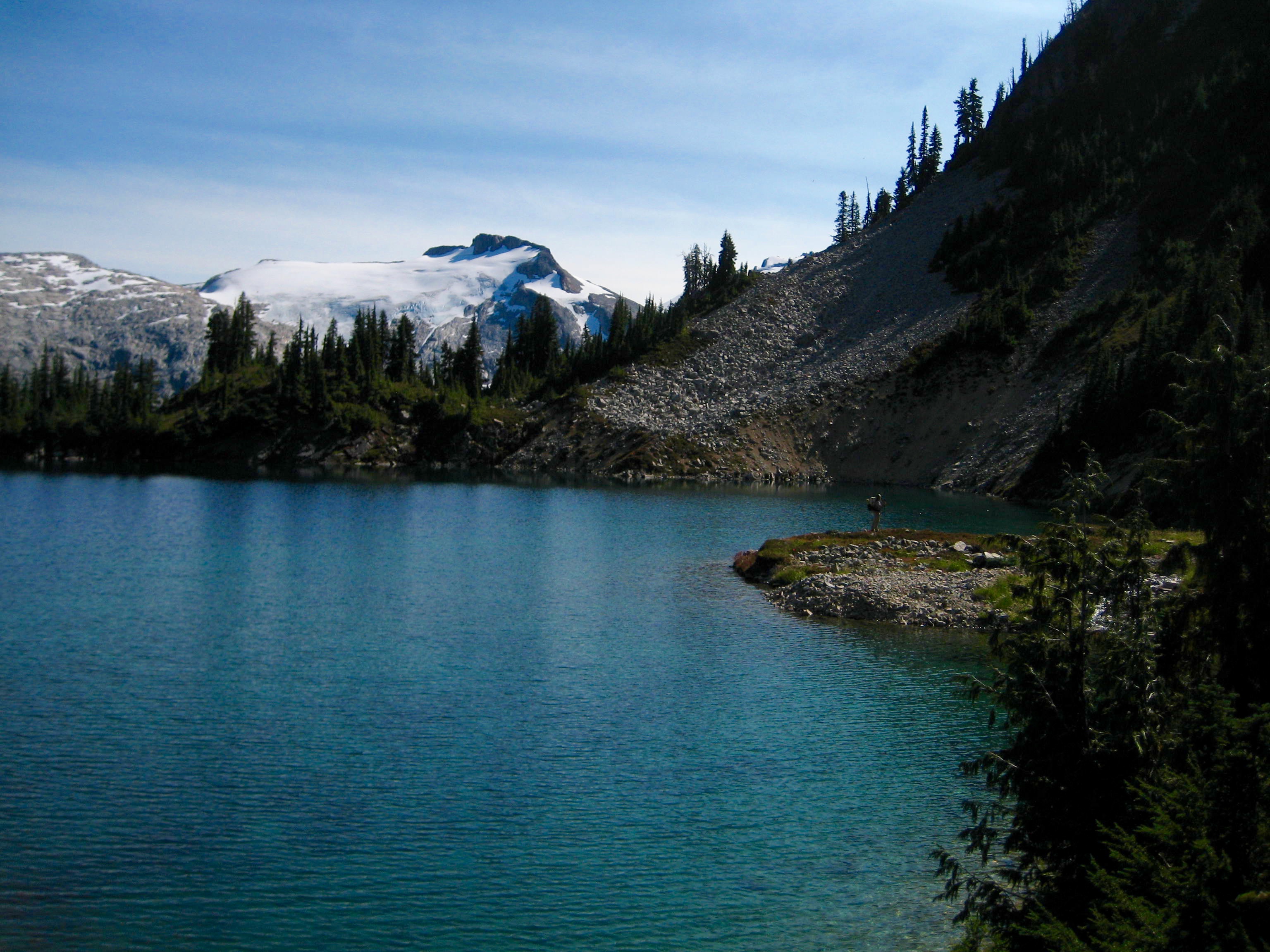 Wiley Peak with snow field and deep blue Lower East Lake in the American Chilliwack Mountains