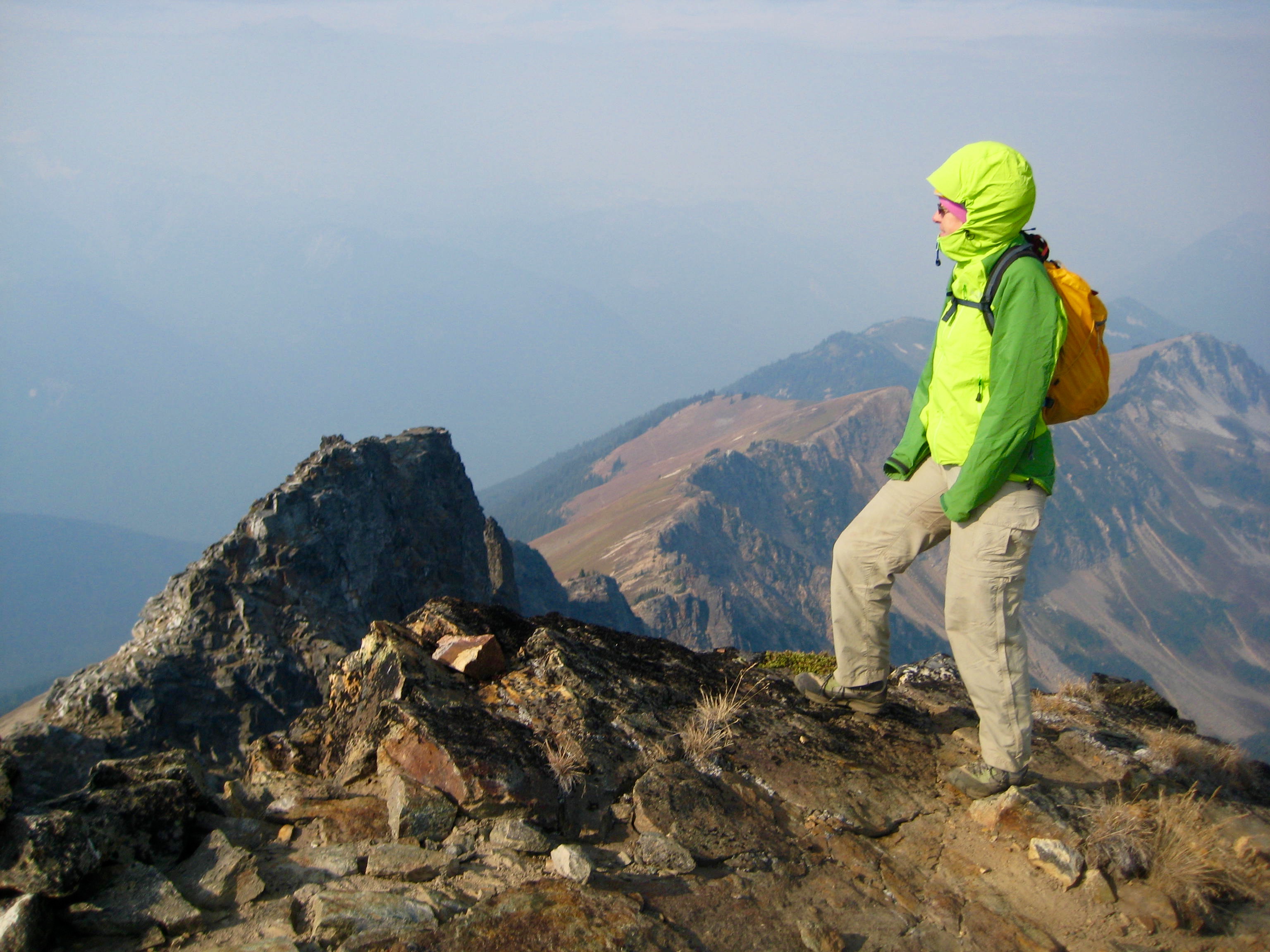 mountain climber standing on the cold, windy summit on Plummer Mountain in the Glacier Peak WIlderness