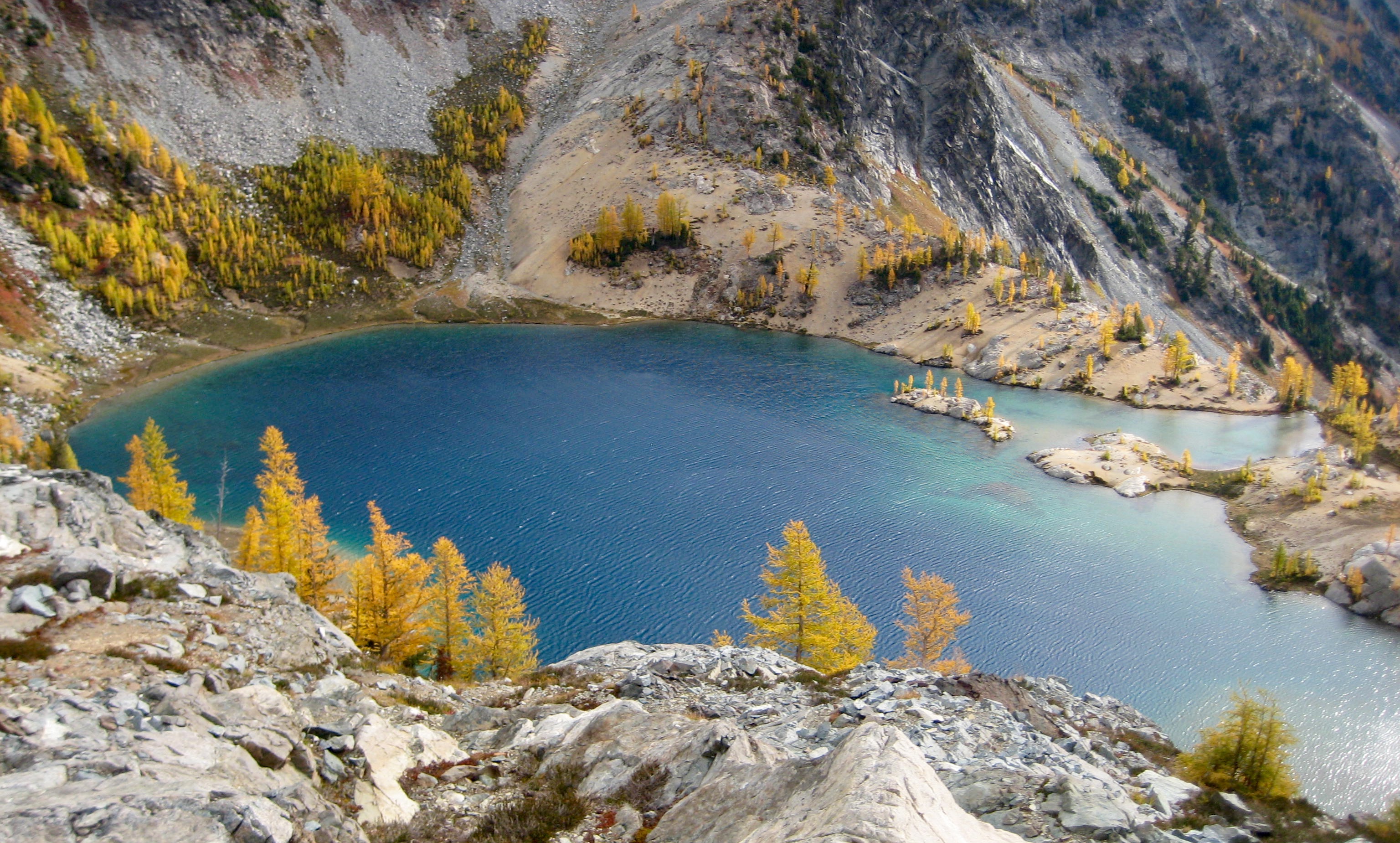 Lower Ice Lake with golden larch trees and granite slab shoreline