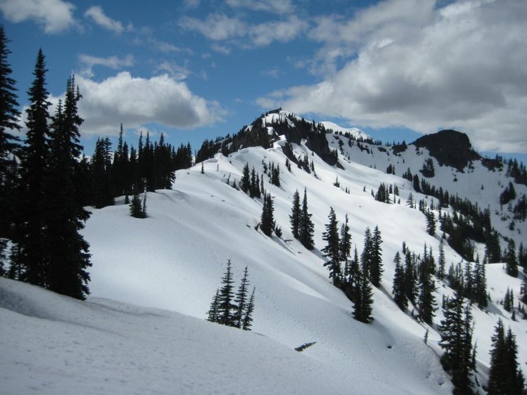 Looking up a snowy ridge at broad summit of Seymour Peak