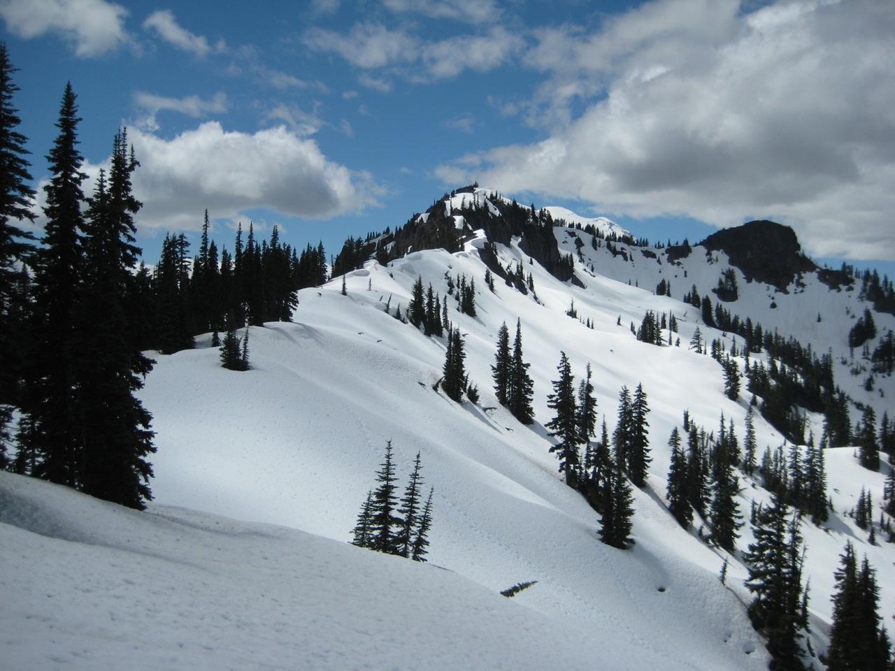Looking up a snowy ridge at broad summit of Seymour Peak